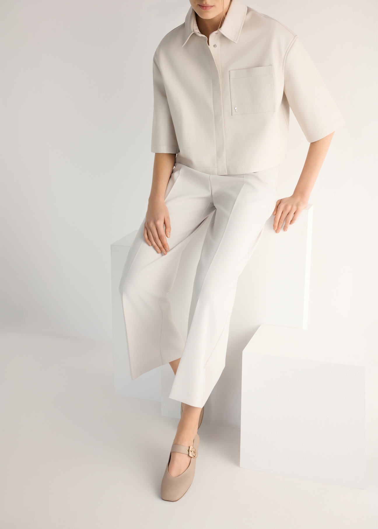 Dámske kožené balerínky v chladnej béžovej farbe BUTYD-1244-1K(W26), pohľad spredu na produkt na nohách modelky.