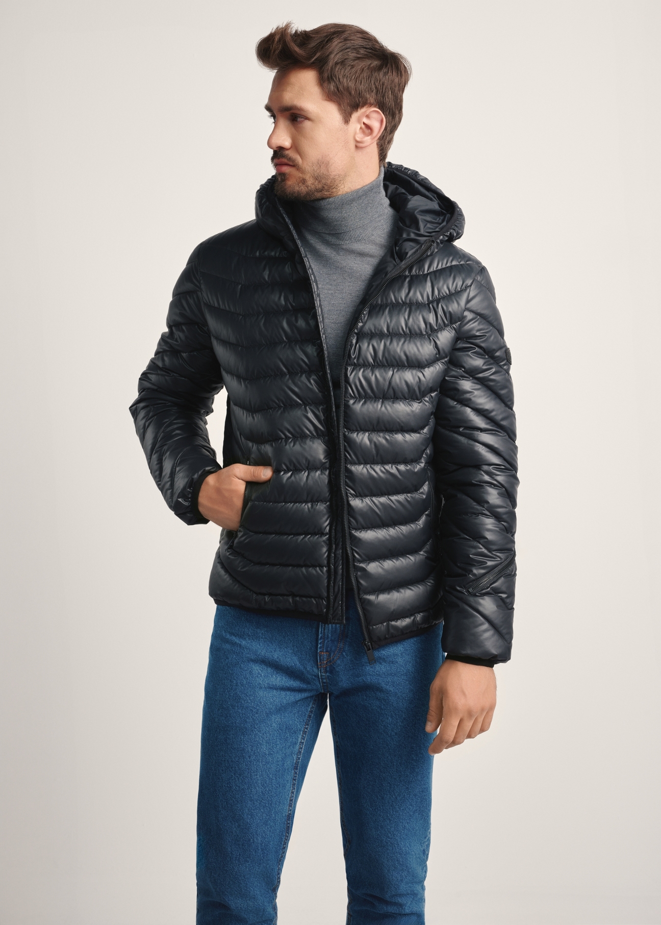 Pánska bunda v čiernej farbe KURMT-0380-99(Z25), pohľad spredu na produkt na modelke, viditeľná polovica siluety.