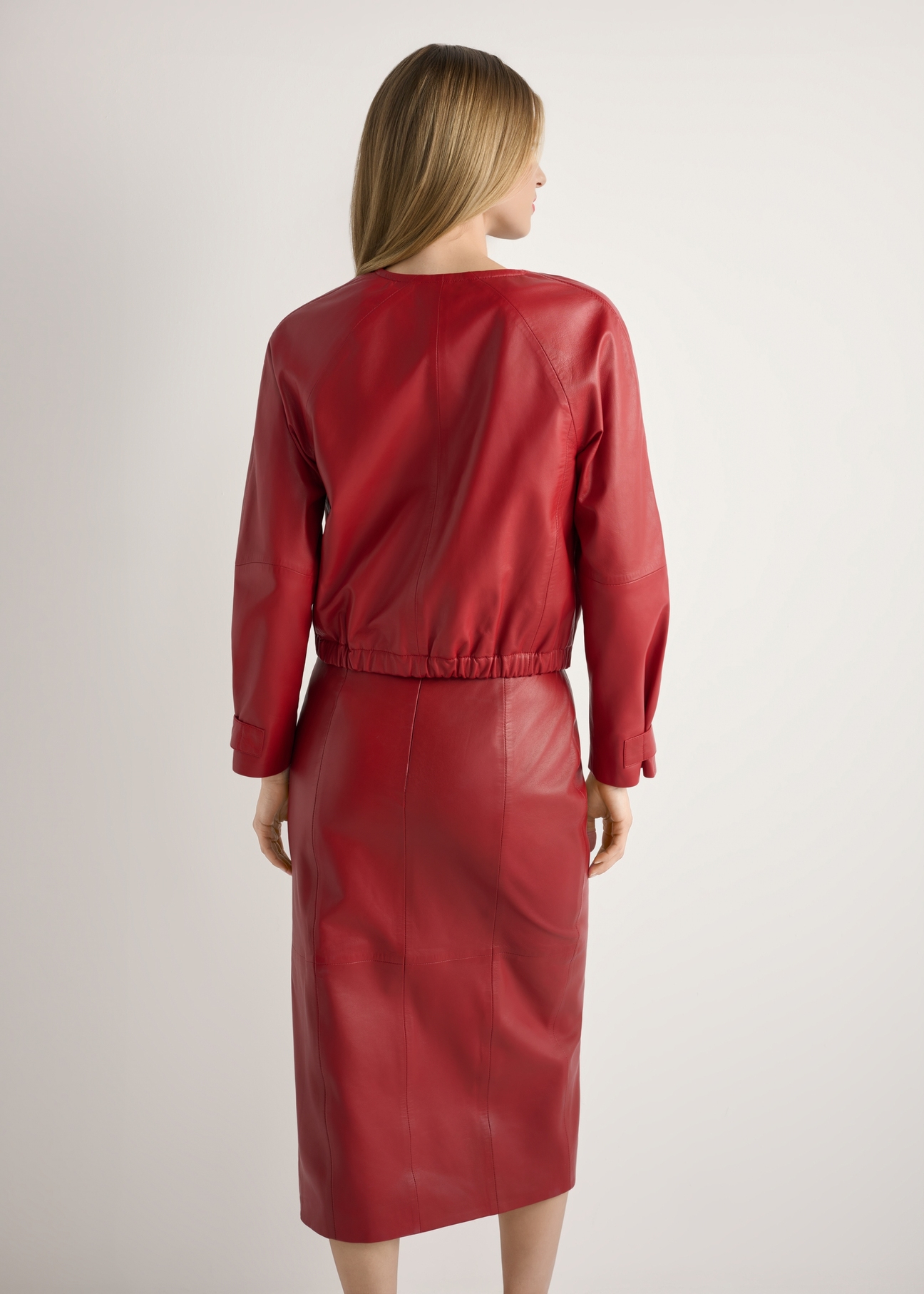 Dámska červená kožená bunda KURDS-0588-4B(W26), pohľad na modelku zozadu. Viditeľná polovica siluety.