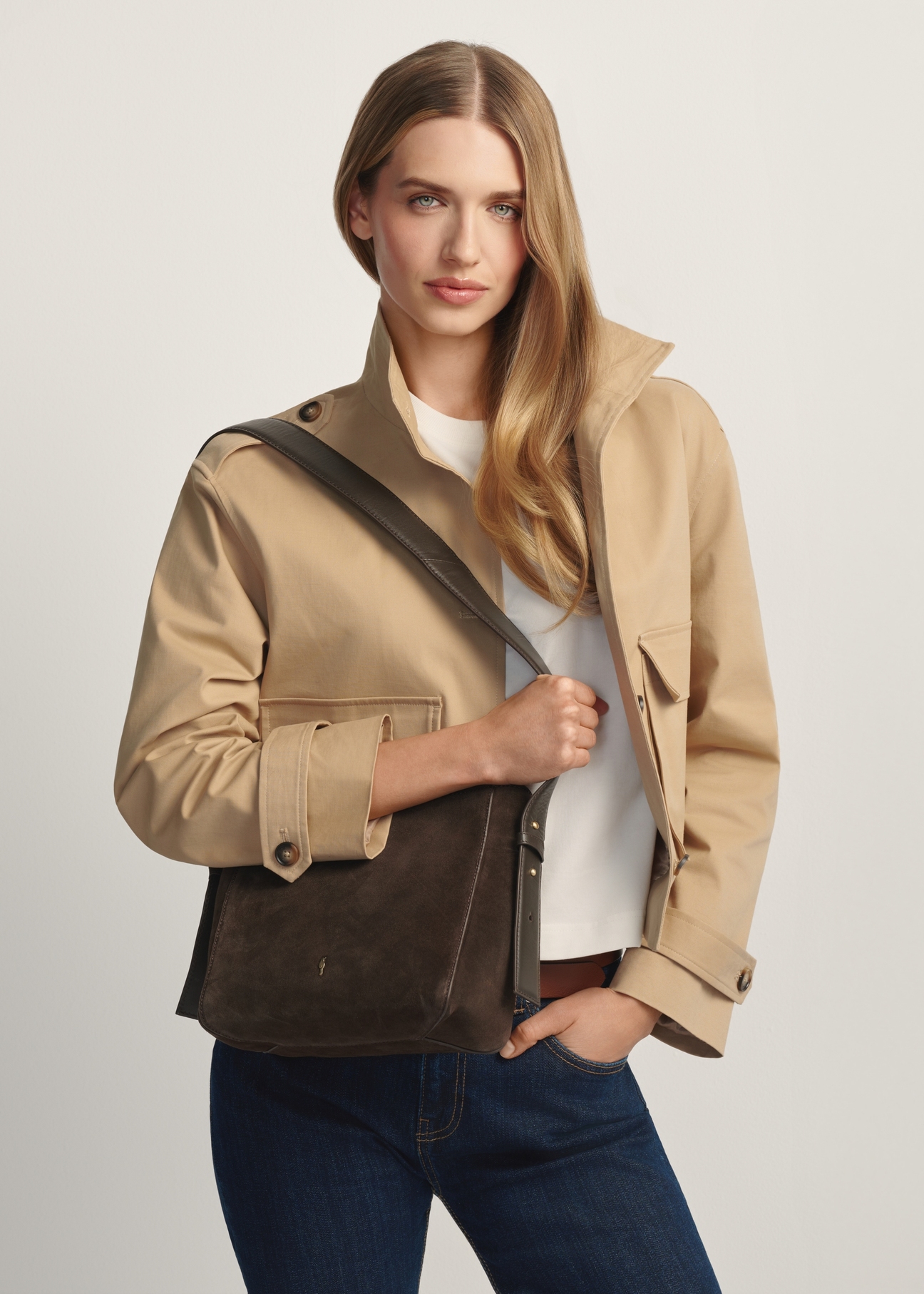 Dámska hnedá kožená kabelka TORES-1251-1I(W26) - diagonálny pohľad na produkt, na modelke, na svetlom pozadí. Viditeľná silueta po kolená.