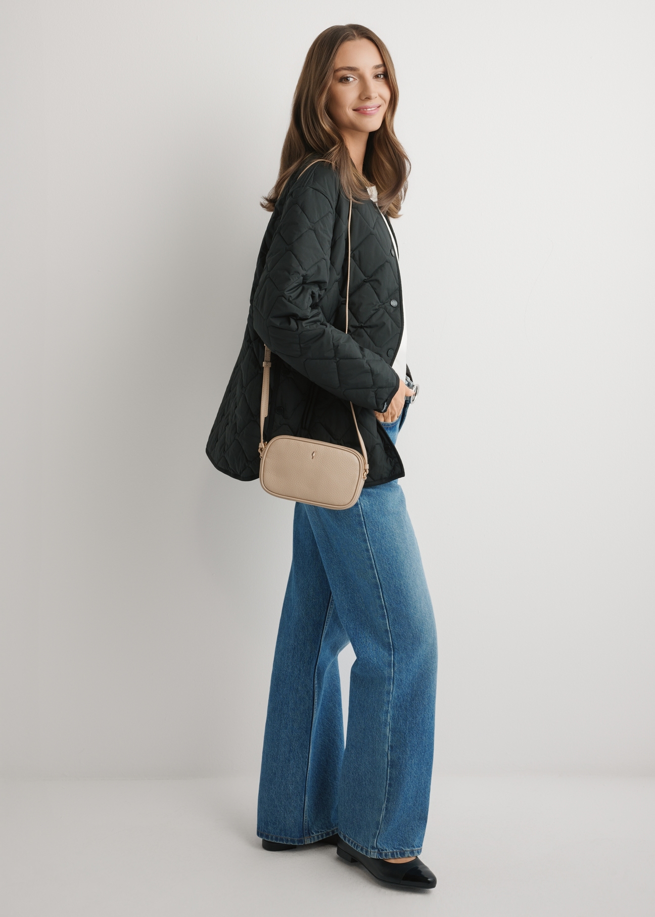 Malá béžová kožená dámska kabelka TORES-0466E-1B(W26), pohľad na produkt spredu na modeli, viditeľná celá silueta.