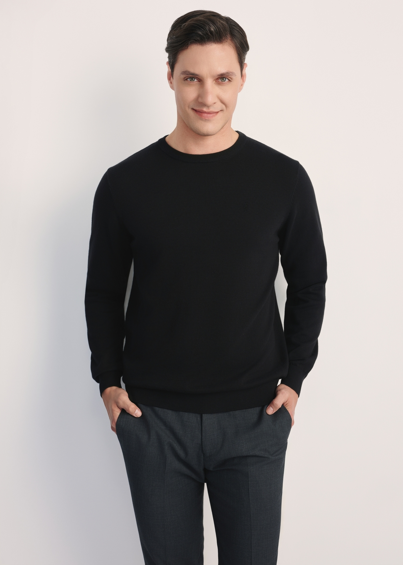 Čierny pánsky základný sveter SWEMT-0114A-99(Z24), pohľad na produkt spredu na modelke, viditeľná polovica siluety.