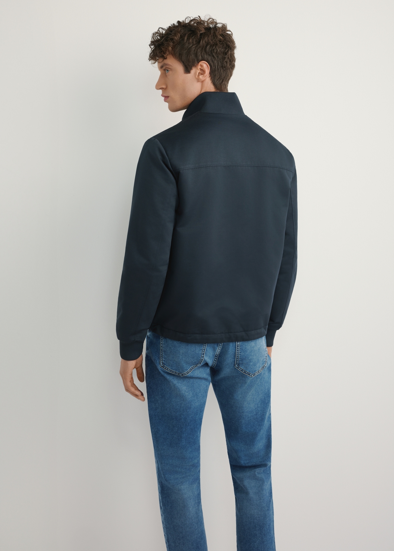 Pánska tmavomodrá prechodná bunda KURMT-0404-7D(W26), pohľad na produkt zozadu na modeli. Viditeľná polovica siluety.