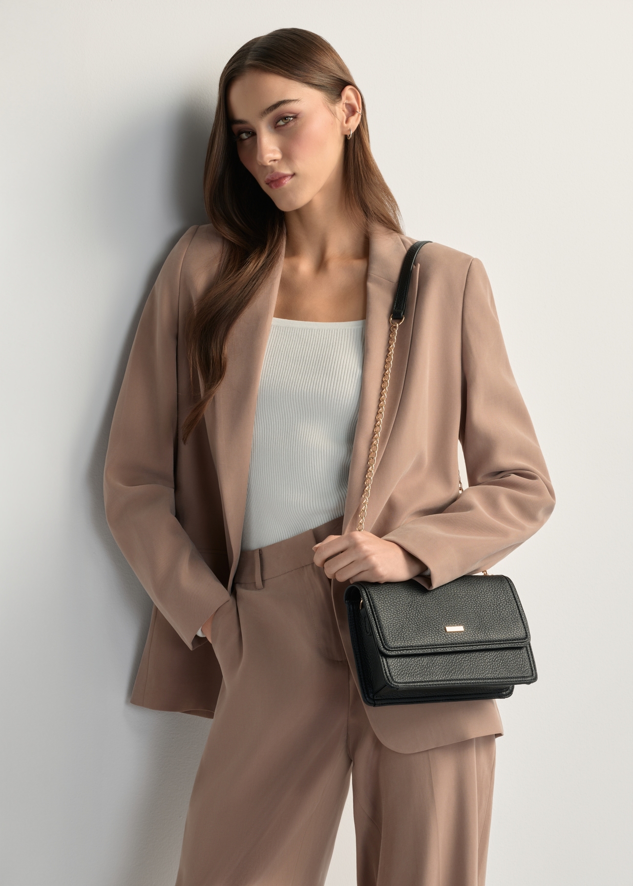 Malá, elegantná dámska kabelka TOREC-1015-99(W26), pohľad spredu na produkt na modelke, viditeľná polovica siluety.