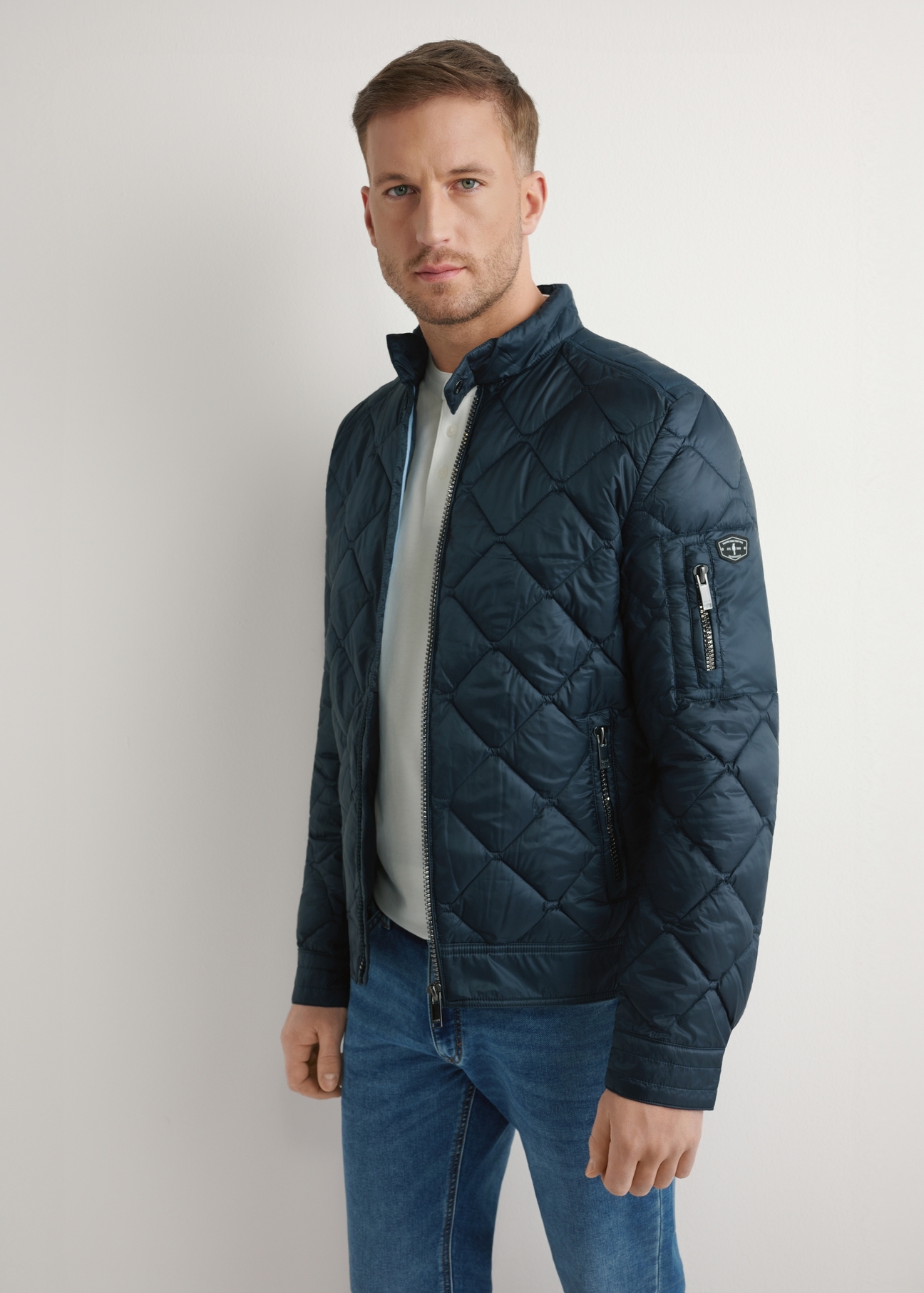 Marineblaue Steppjacke für Herren KURMT-0327-7C(W26) – Vorderansicht, Modell vor hellem Hintergrund. Knielange Silhouette sichtbar.