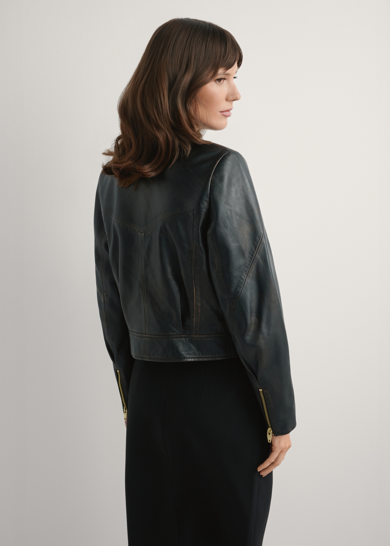 Dámska vintage krátka kožená bunda KURDS-0573-9J(W26), pohľad na produkt zozadu na modelke. Viditeľná polovica siluety.