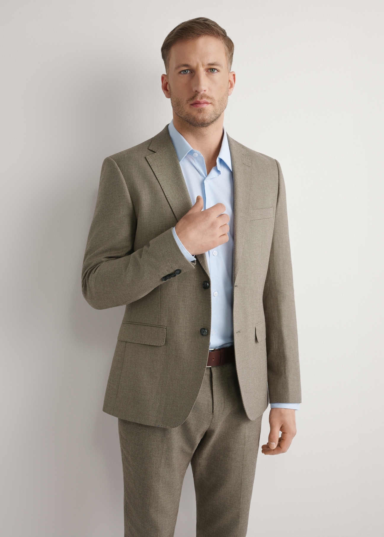 Pánske tmavohnedé sako MARMT-0013-1I(W26), pohľad spredu na produkt na modelke. Viditeľná polovica siluety.