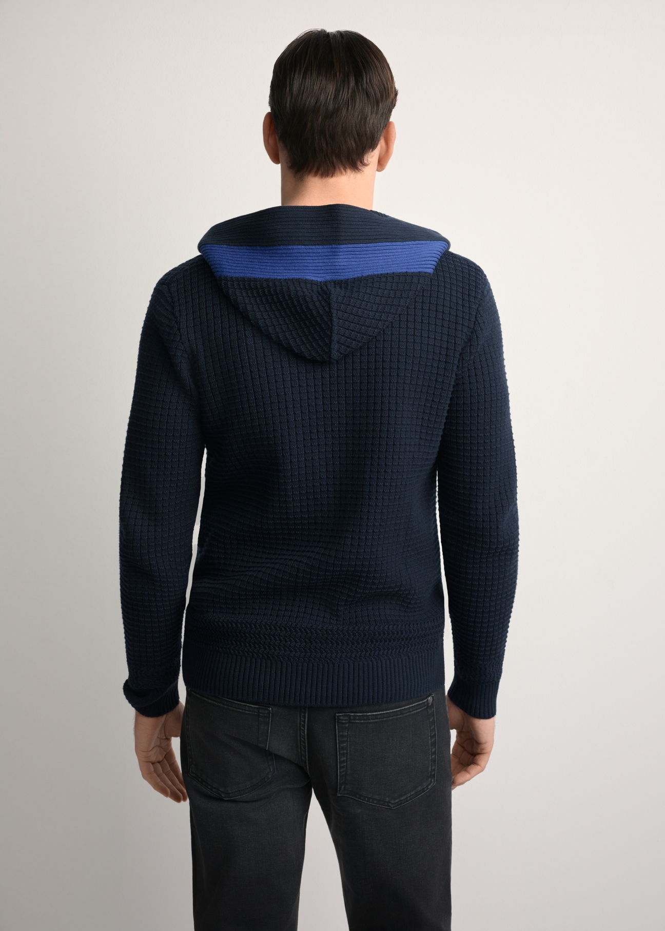 Pánsky tmavomodrý sveter s kapucňou SWEMT-0182-68(Z25), pohľad na modelku zozadu. Viditeľná polovica siluety.