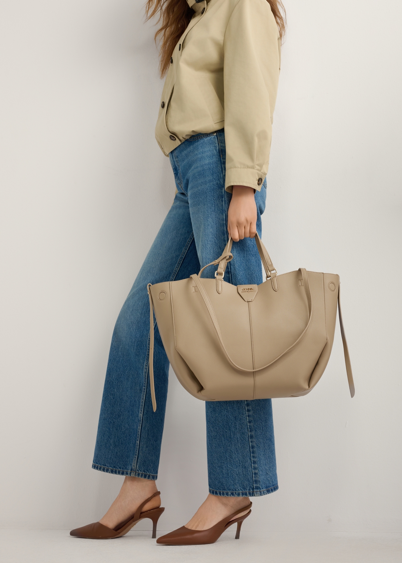 Hnedé lodičky s otvoreným podpätkom BUTYD-1078A-1D(W26), bočný pohľad na produkt na nohách modelky, na svetlom pozadí.