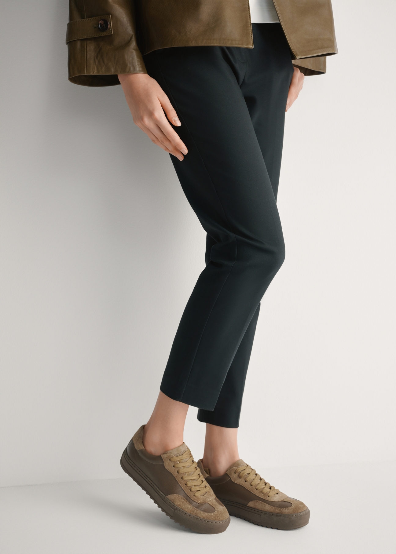 Dámske kožené tenisky v chladnej béžovej farbe BUTYD-1260-1K(W26), bočný pohľad na produkt na nohách modelky.