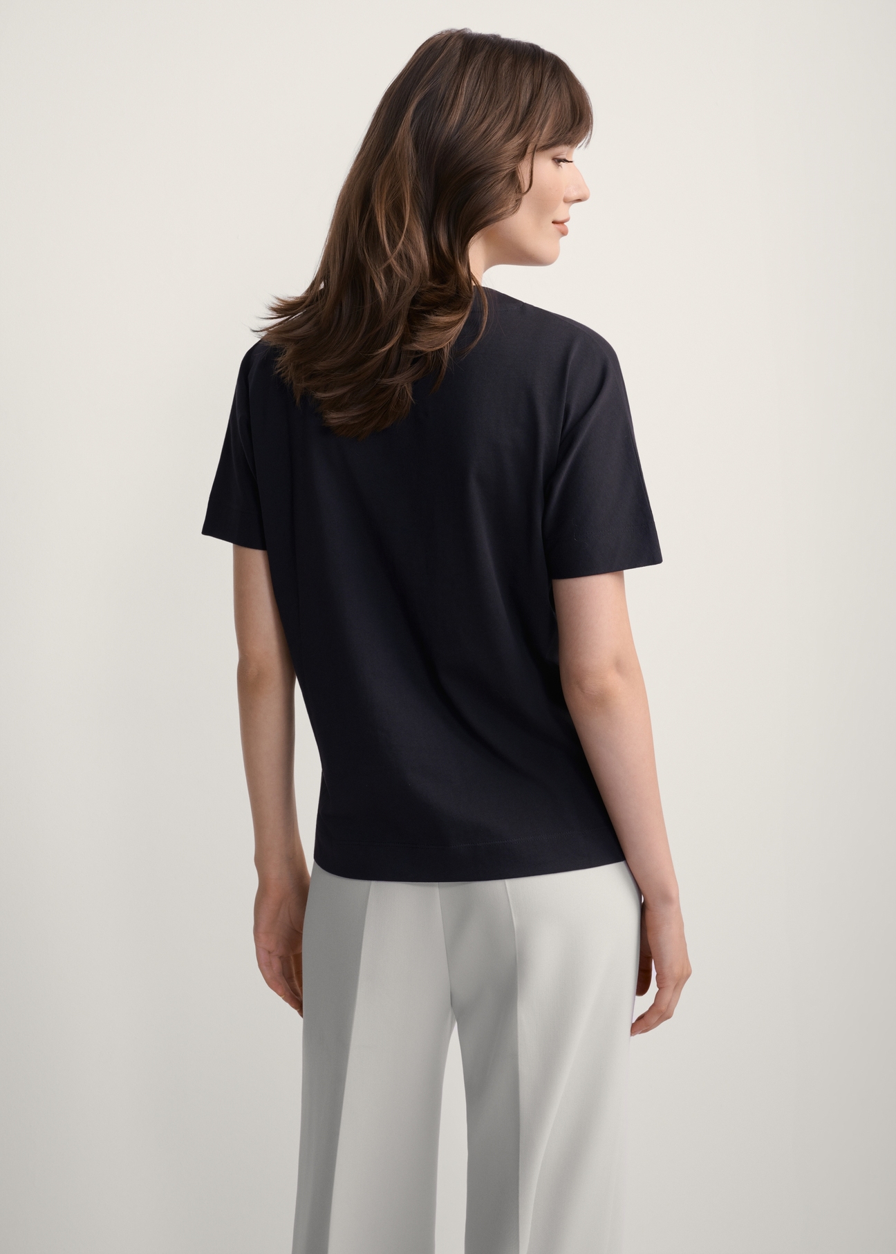 Dámske čierne tričko s potlačou TSHDT-0146-99(Z25), pohľad na produkt zozadu na modelke. Viditeľná polovica siluety.