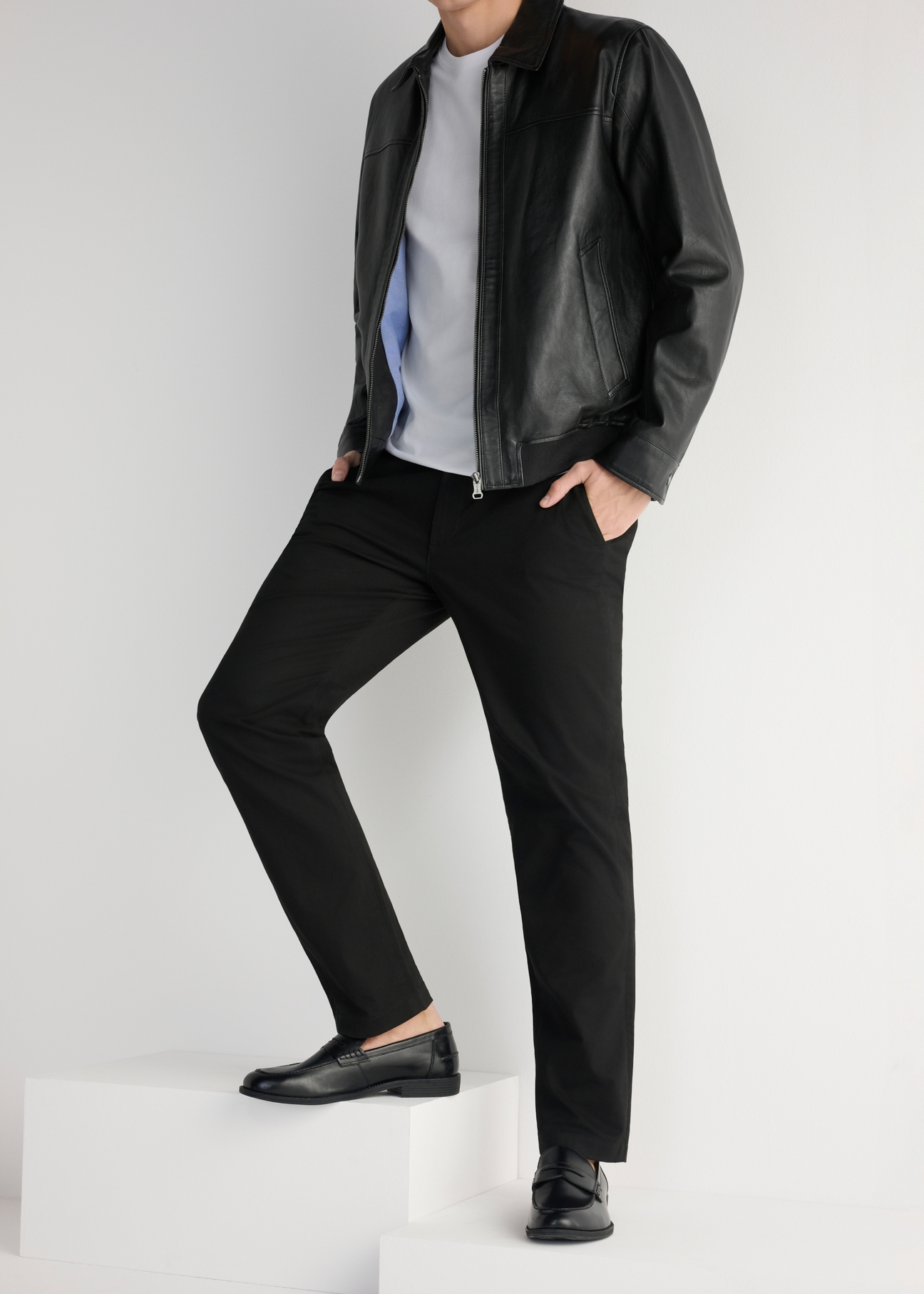 Pánske čierne kožené mokasíny BUTYM-0482-99(W25), bočný pohľad na produkt na modeli, viditeľná polovica siluety.