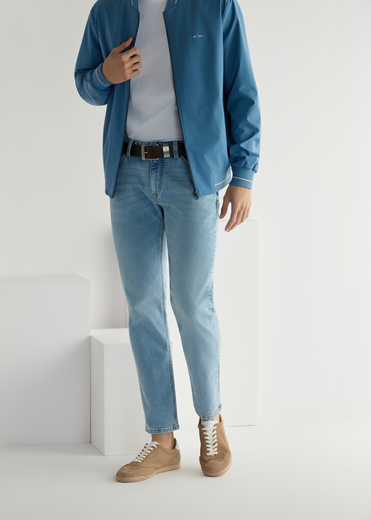 Béžové kožené športové topánky BUTYM-0534-1B(W26), pohľad spredu na modelkine nohy, na svetlom pozadí.