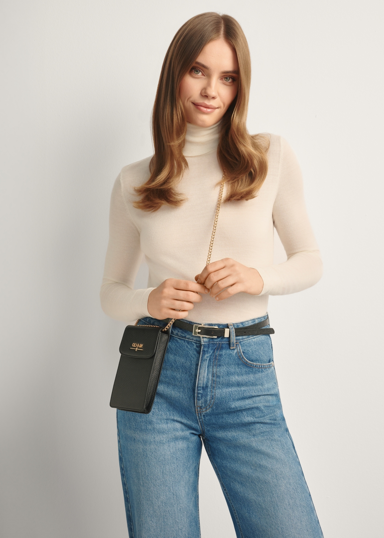 Čierna dámska kabelka TOREC-1112-99(Z25), pohľad spredu na produkt na modelke, viditeľná polovica siluety.