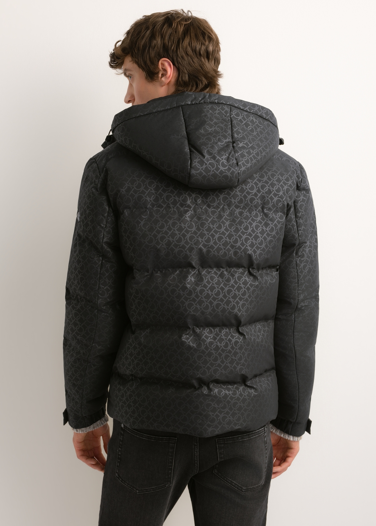 Pánska tmavosivá monogramová bunda KURMT-0444-9P(Z26), pohľad na produkt zozadu na modelke. Viditeľná polovica siluety.