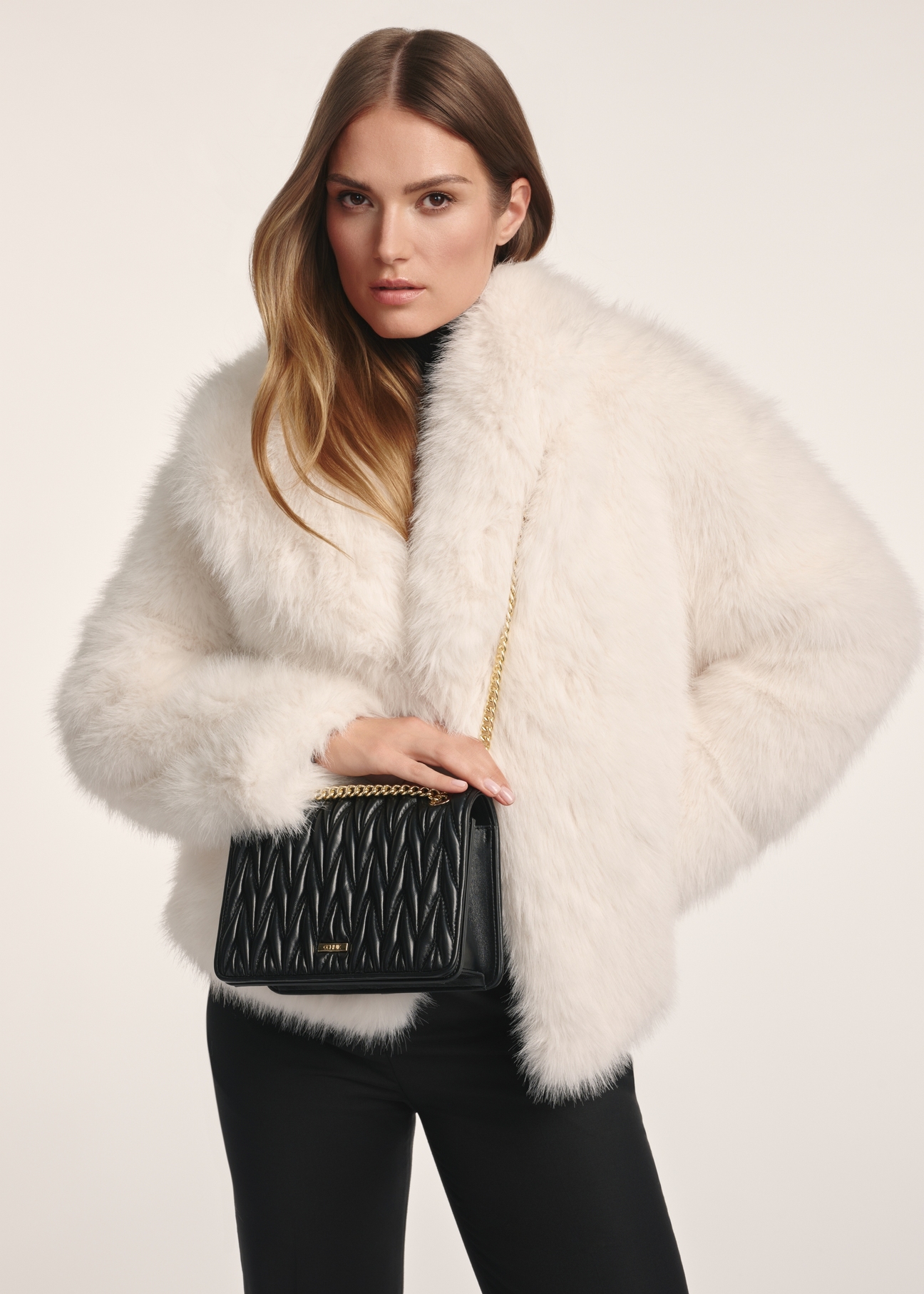 Čierna dámska kabelka s retiazkou TOREC-1102-99(Z25), pohľad na modelku. Viditeľná polovica siluety.