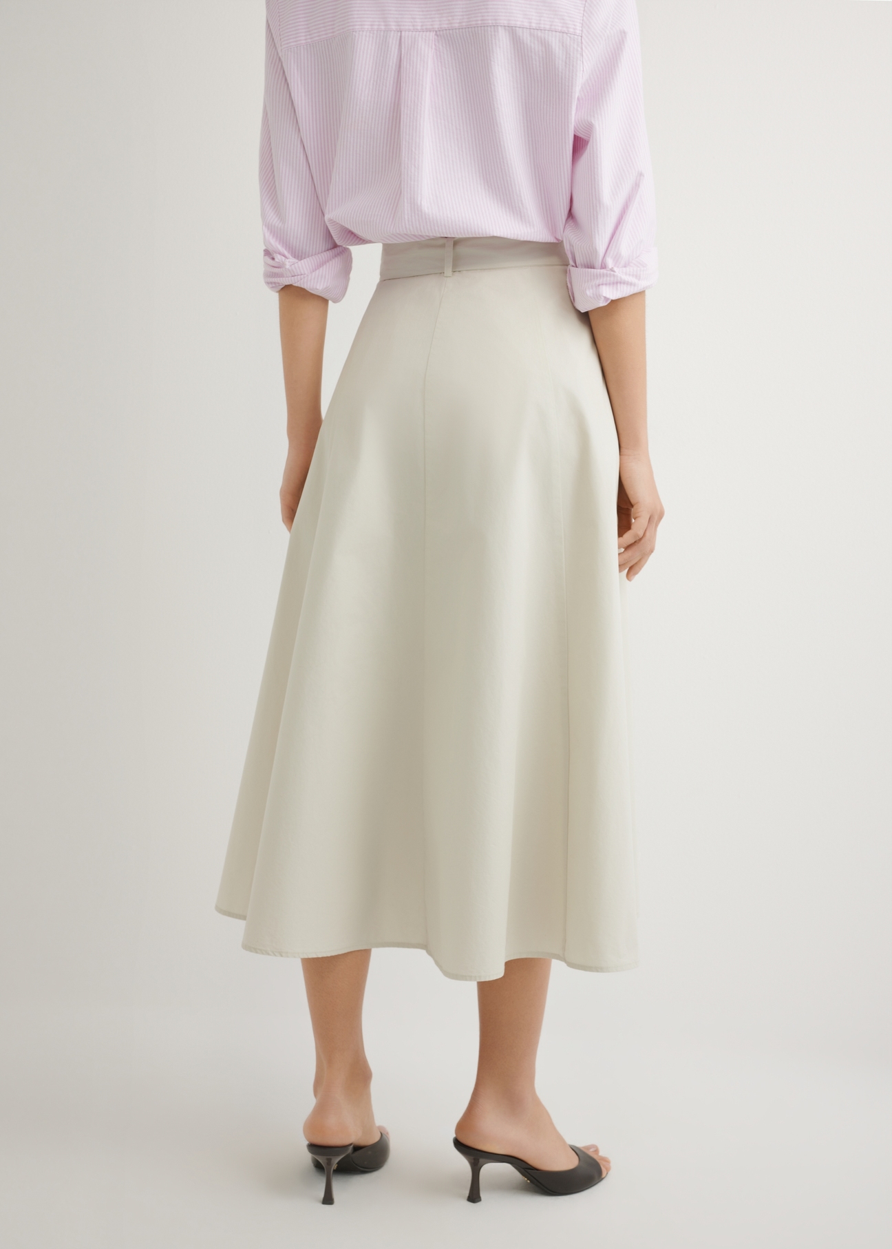 Béžová midi sukňa SPCDT-0123-1A(W26), pohľad zozadu na produkt na modelke. Viditeľná polovica siluety.