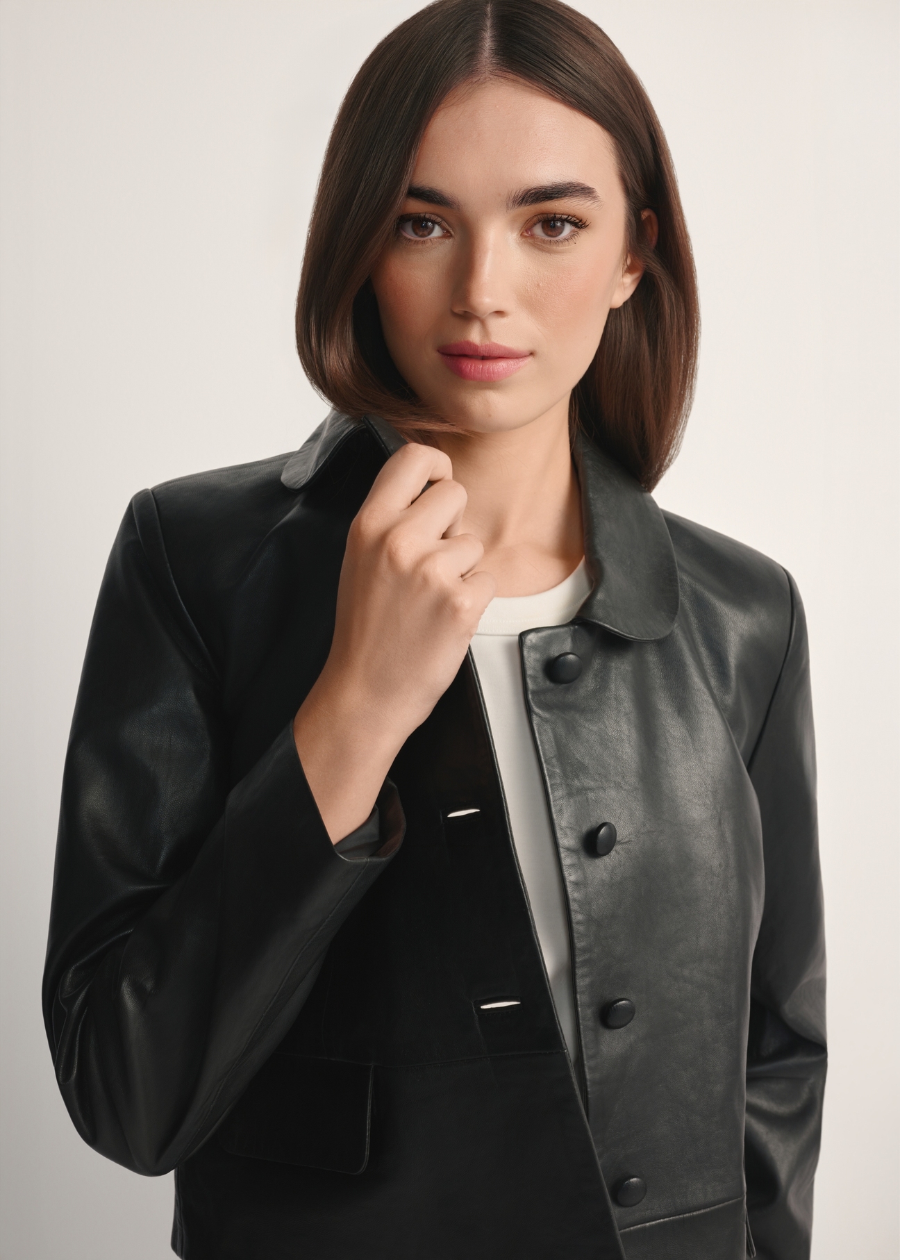 Čierna krátka dámska kožená bunda KURDS-0598-99(W26), pohľad spredu na produkt na modelke, viditeľná polovica siluety.-02