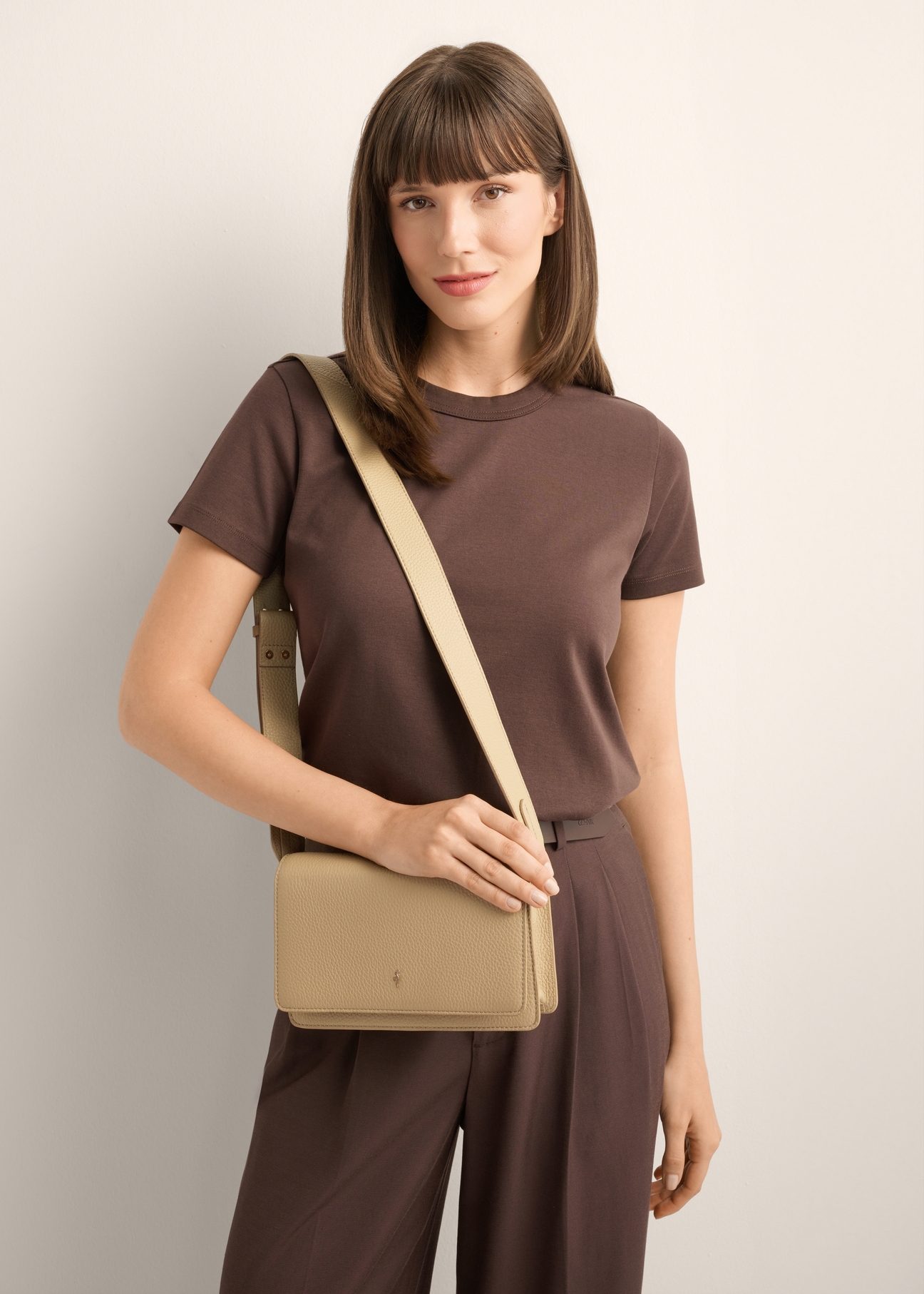 Béžová elegantná kožená dámska kabelka TORES-1356-1B(Z26), pohľad spredu na produkt na ramene modelky, na svetlom pozadí.