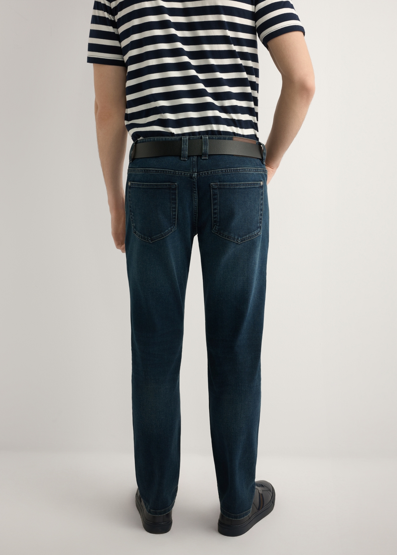 Pánske tmavomodré džínsové nohavice JEAMT-0022-7C(W26), pohľad na produkt zozadu na modeli. Viditeľná polovica siluety.