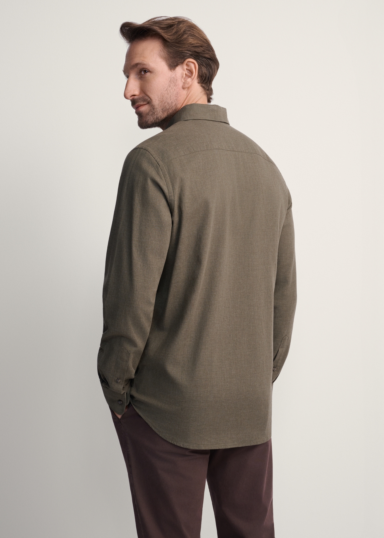 Pánska khaki košeľa KOSMT-0299A-55(Z25), pohľad na produkt zozadu na modelke. Viditeľná polovica siluety.