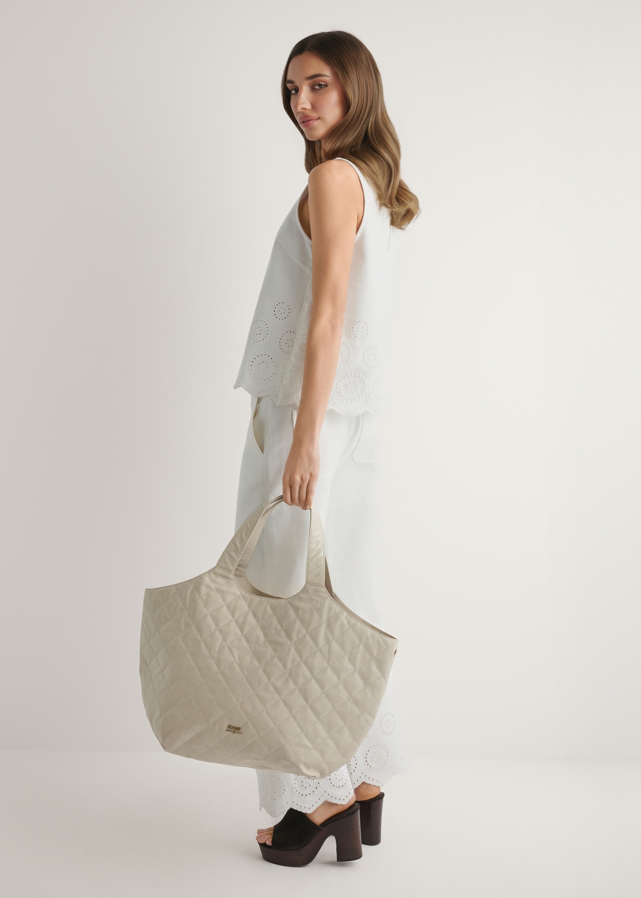 Veľká prešívaná kožená dámska kabelka TORES-1306-0B(W26), pohľad spredu na produkt v ruke modelky.