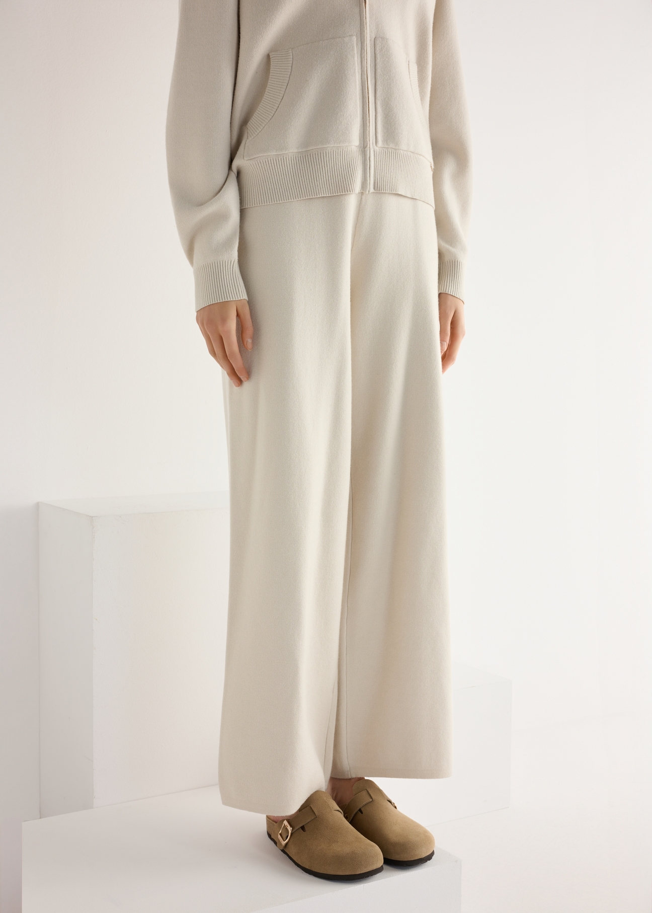 Dámske semišové žabky v chladnej béžovej farbe BUTYD-1267-1K(W26), diagonálny pohľad na produkt na nohách modelky.