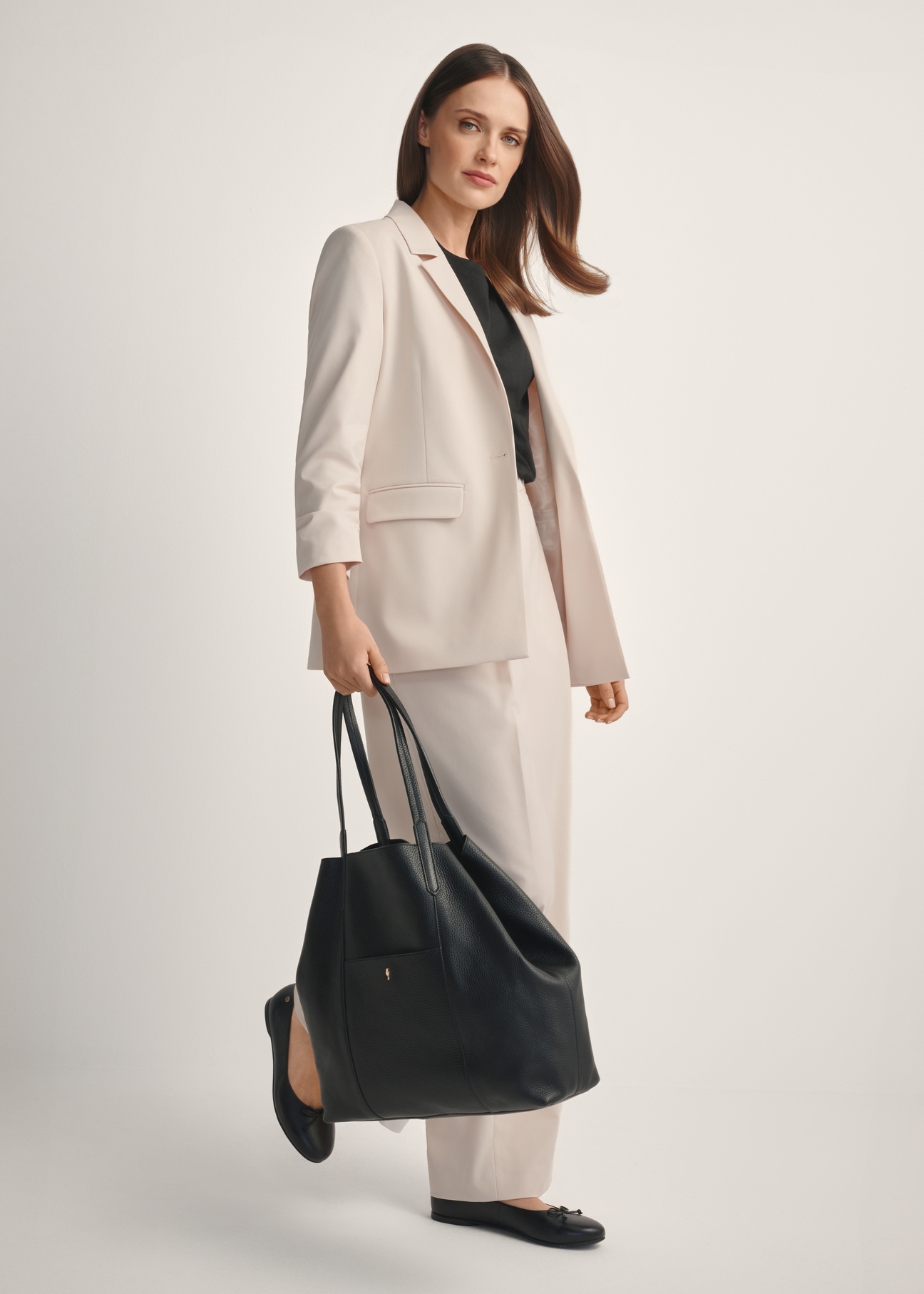 Veľká čierna kožená nákupná taška TORES-1212-9I(W26), diagonálny pohľad na produkt na modelke, viditeľná je celá silueta.