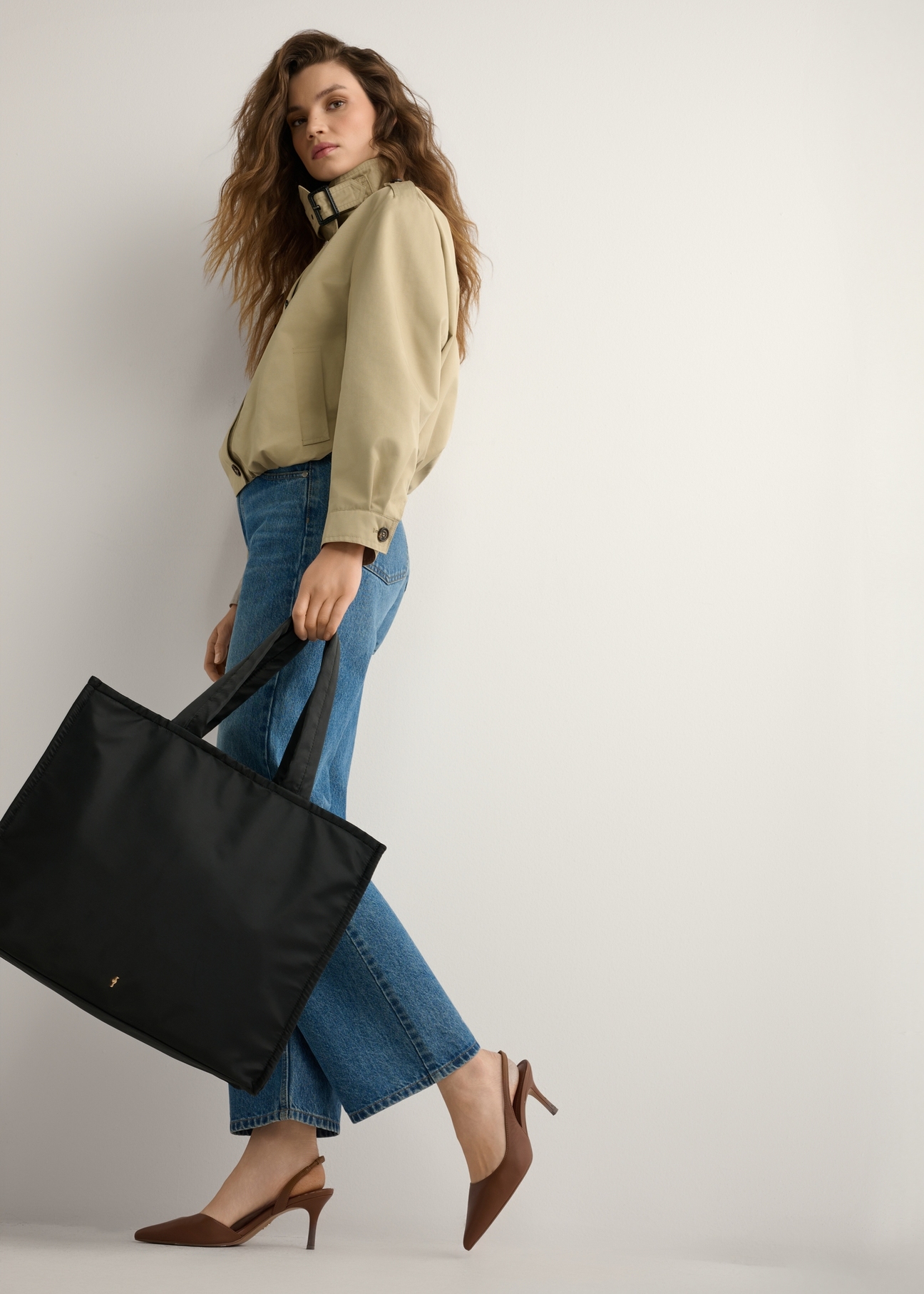 Čierna veľká dámska kabelka TOREN-0343-99(W26), pohľad na produkt spredu na modelke, viditeľná celá silueta.