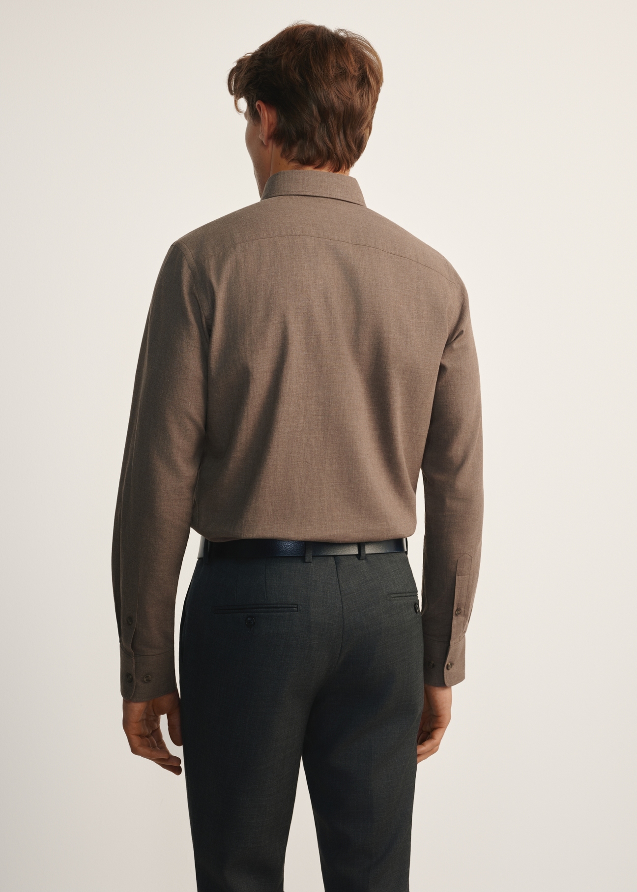 Pánska hnedá košeľa KOSMT-0299A-90(Z25), pohľad na produkt zozadu na modeli. Viditeľná polovica siluety.