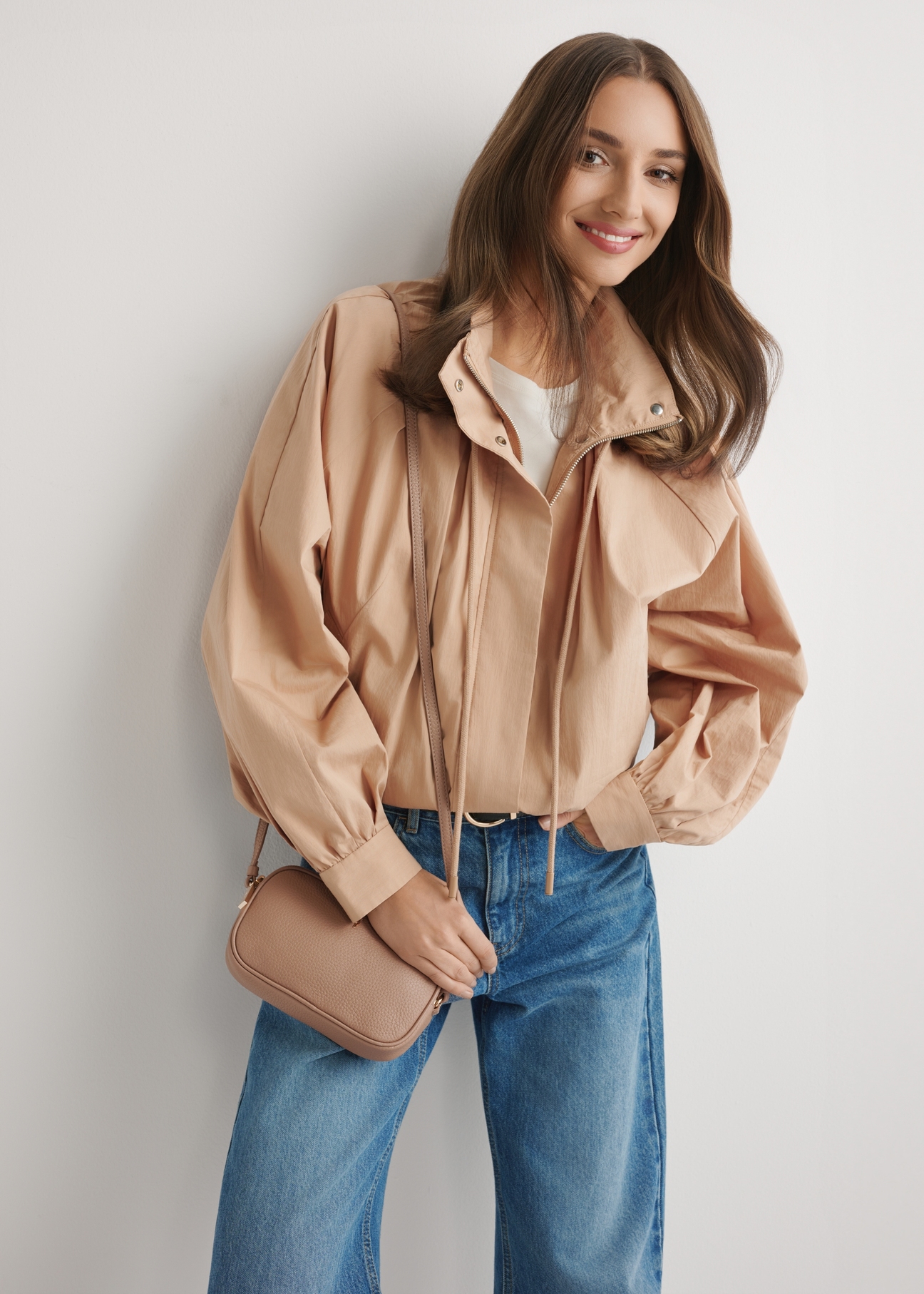 Malá ružová kožená dámska kabelka TORES-0466E-5D(W26), pohľad spredu na produkt na modelke, viditeľná polovica siluety.