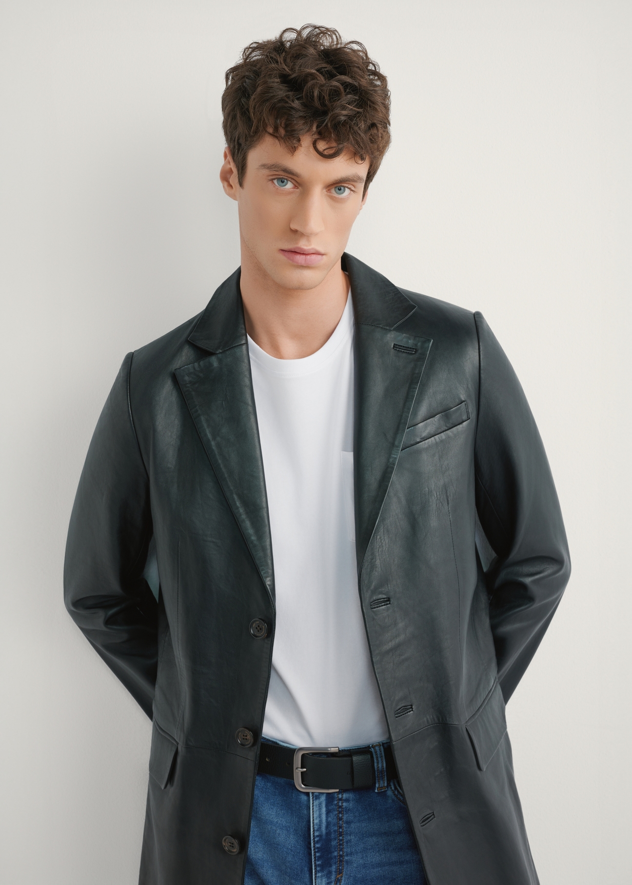 Pánsky čierny kožený kabát KURMS-0388-99(W26) - pohľad spredu na produkt na modelke, na svetlom pozadí. Viditeľná polovica siluety.