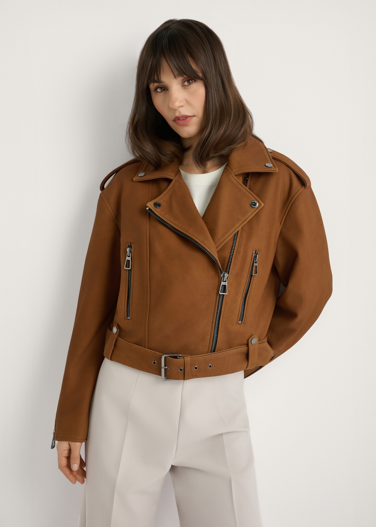Kožená motorkárska bunda v koňakovej farbe KURDS-0610-1F(W26), pohľad spredu na produkt na modelke. Viditeľná polovica siluety.