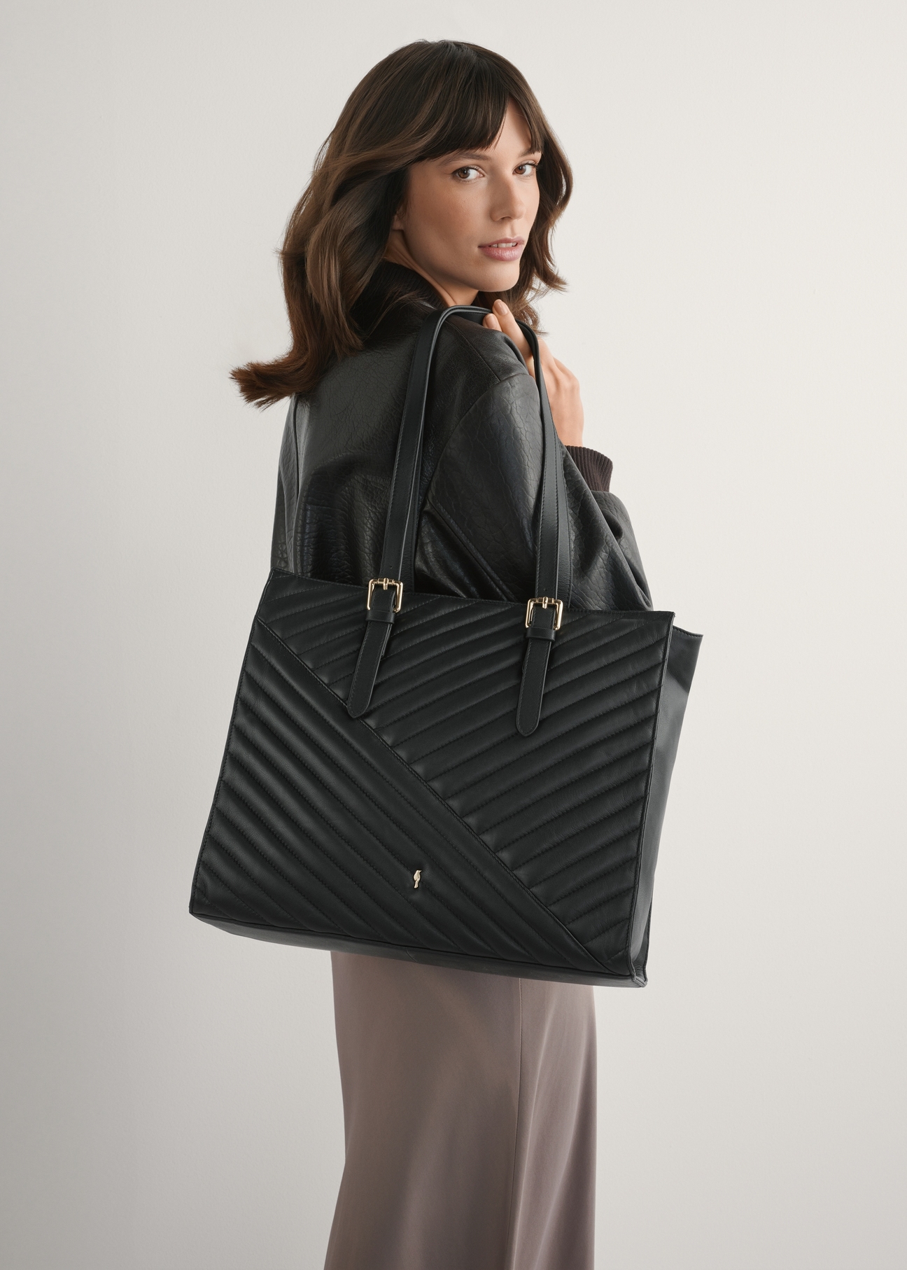 Veľká čierna kožená dámska kabelka TORES-1287-99(W26), pohľad spredu na produkt na modelke, viditeľná polovica siluety.