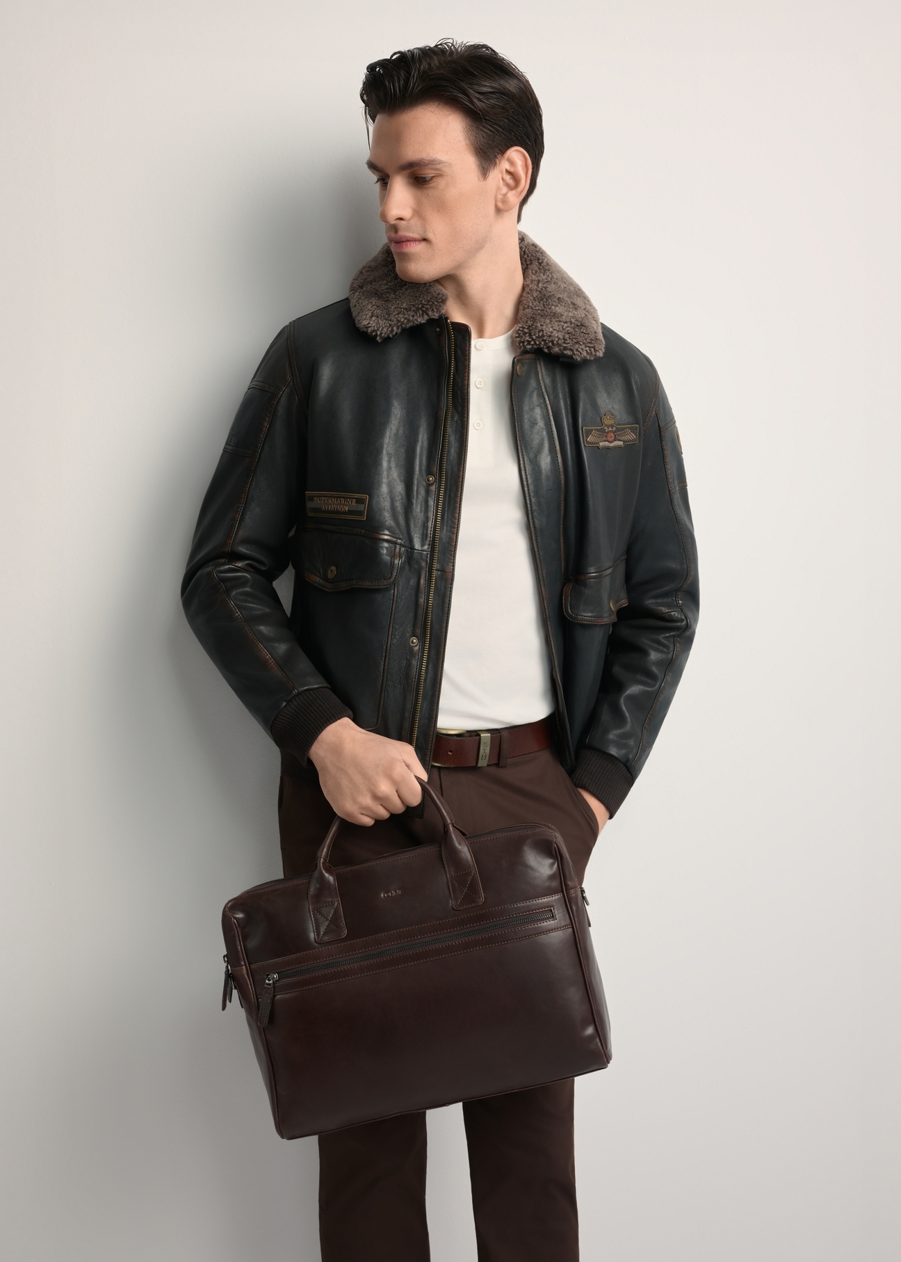 Hnedá kožená pánska taška TORMS-0460-89(Z25) - pohľad spredu na produkt, ktorý drží modelka. Viditeľná polovica siluety.