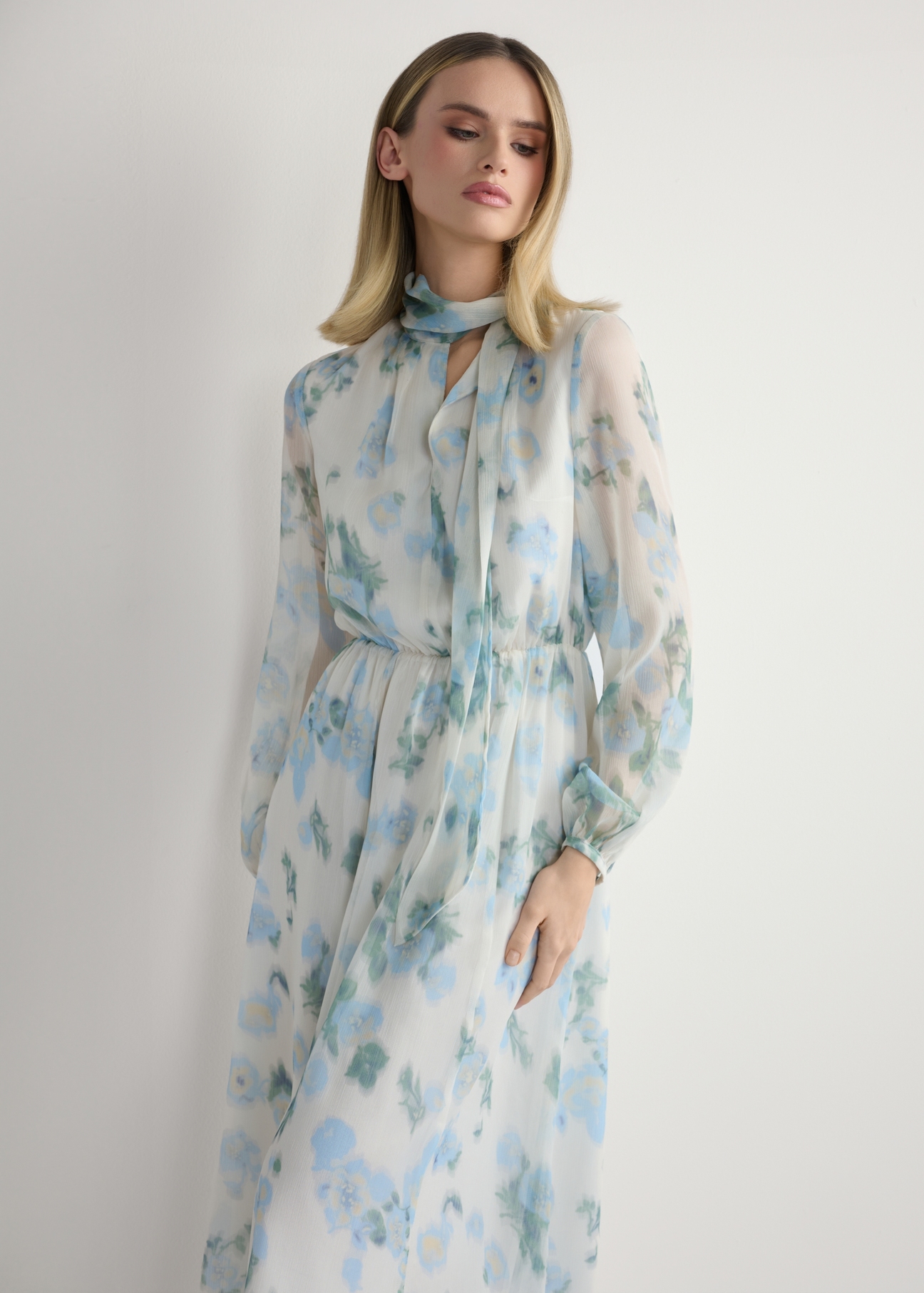 Dámske krémové kvetinové šaty SUKDT-0265-7P(W26), pohľad spredu na výrobok na modelke. Viditeľná polovica siluety.