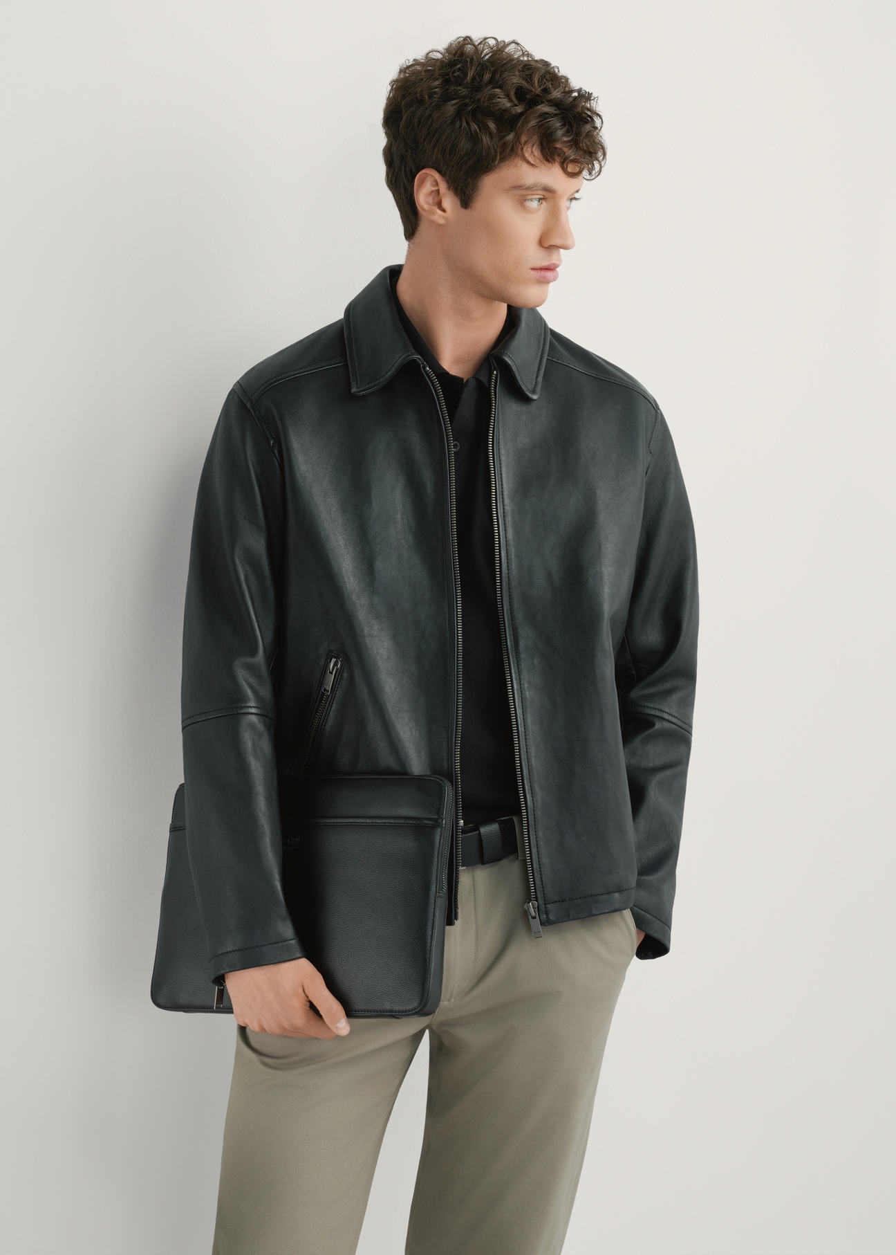 Čierna pánska aktovka na notebook TORMS-0286R-9I(W26), pohľad spredu na produkt na modeli, viditeľná polovica siluety.