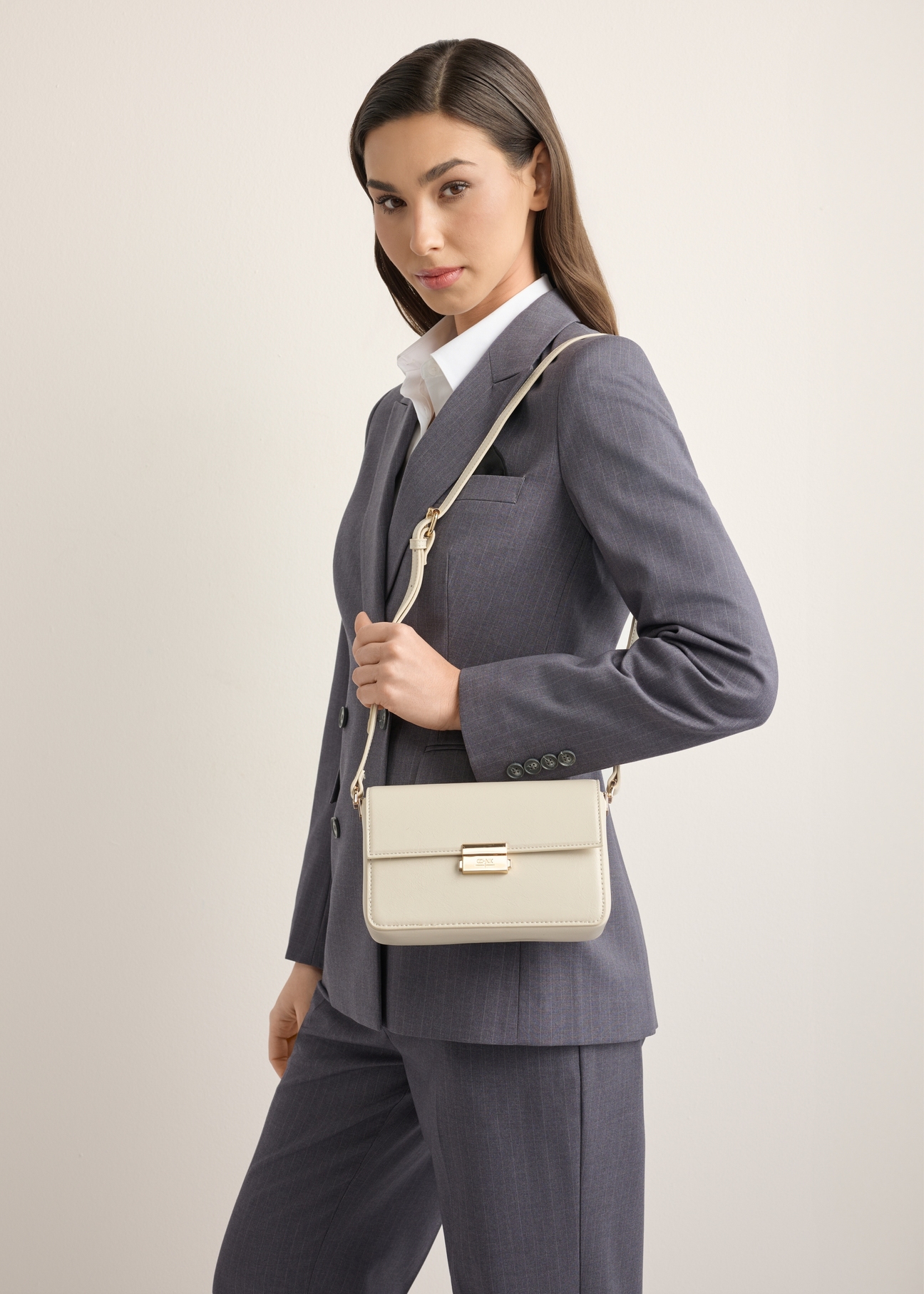 Elegantná krémová dámska kabelka TOREC-1251-0B(Z26), pohľad spredu na produkt na modelke. Viditeľná polovica siluety.