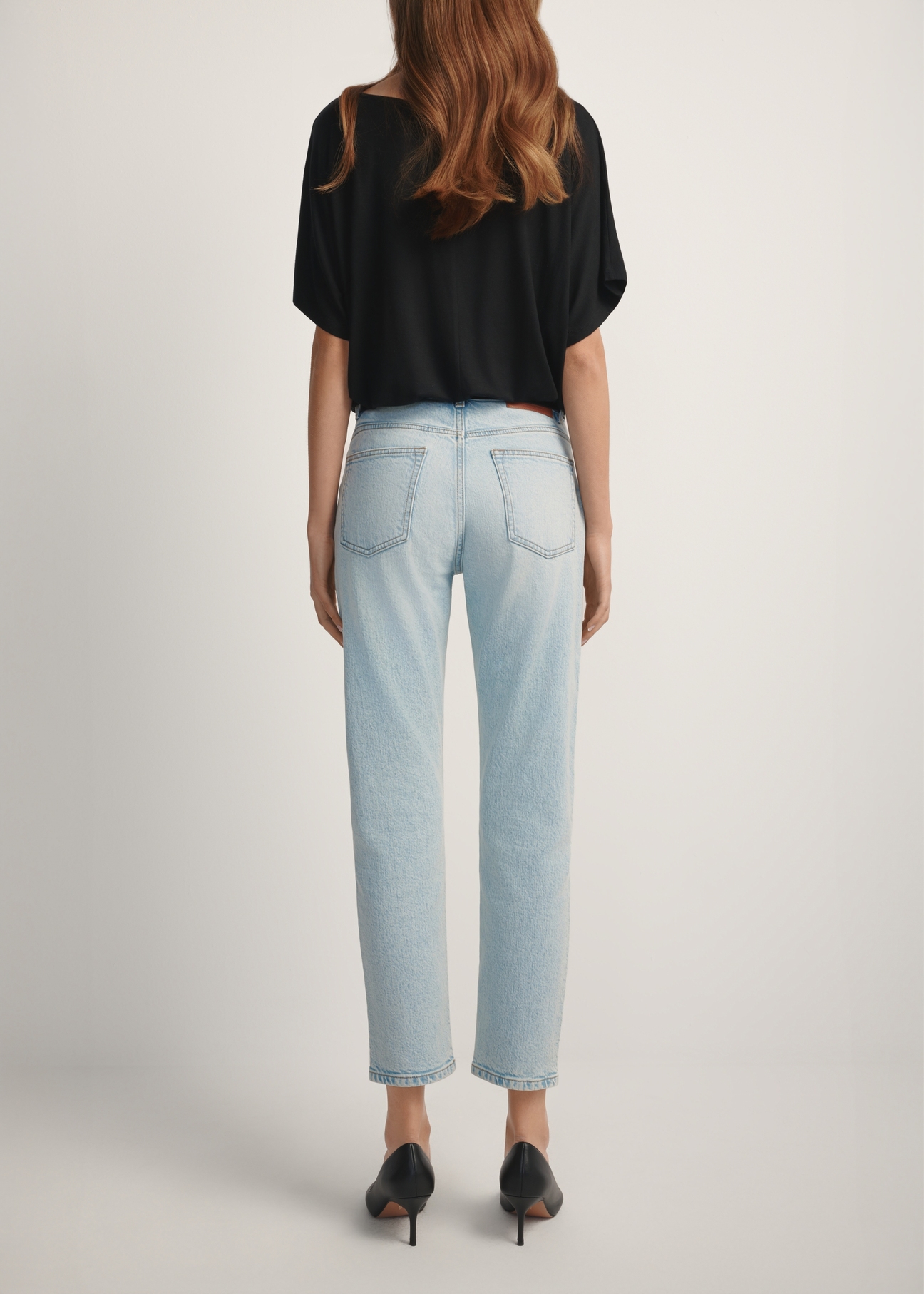 Svetlomodré dámske rifle JEADT-0011-7A(W26), pohľad na modelku zozadu. Viditeľná polovica siluety.