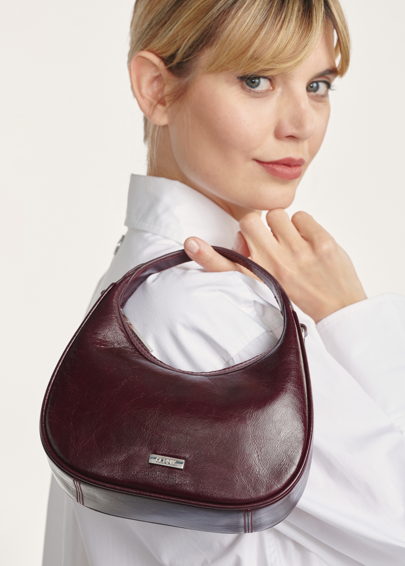 Malá bordová kožená kabelka hobo TORES-1174-49(Z25), detailný záber na modelku na bielom pozadí.
