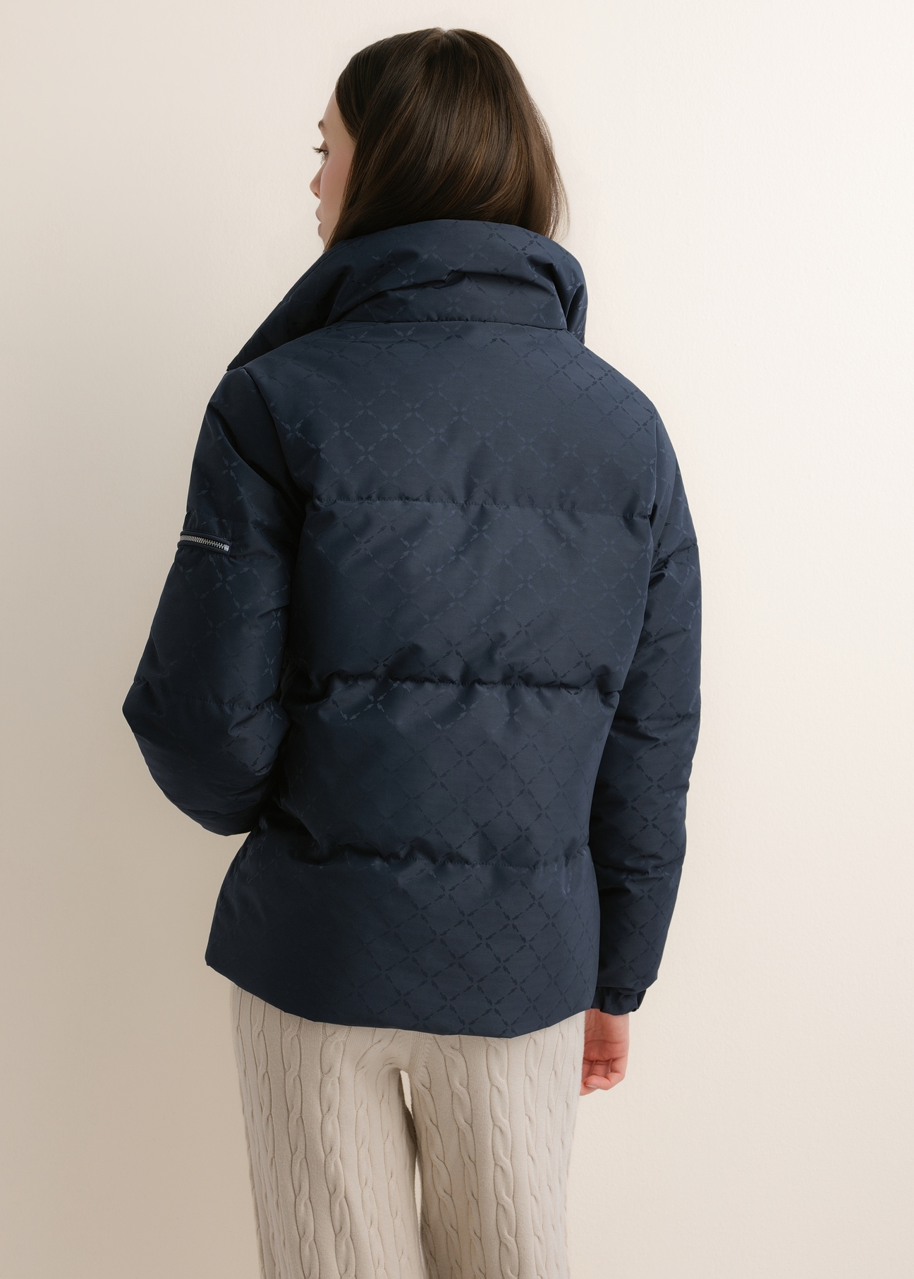 Dámska tmavomodrá bunda s monogramovou potlačou a stojačikom (KURDT-0694-7E(Z26)); pohľad zozadu na modelku, zobrazujúci polovicu postavy.