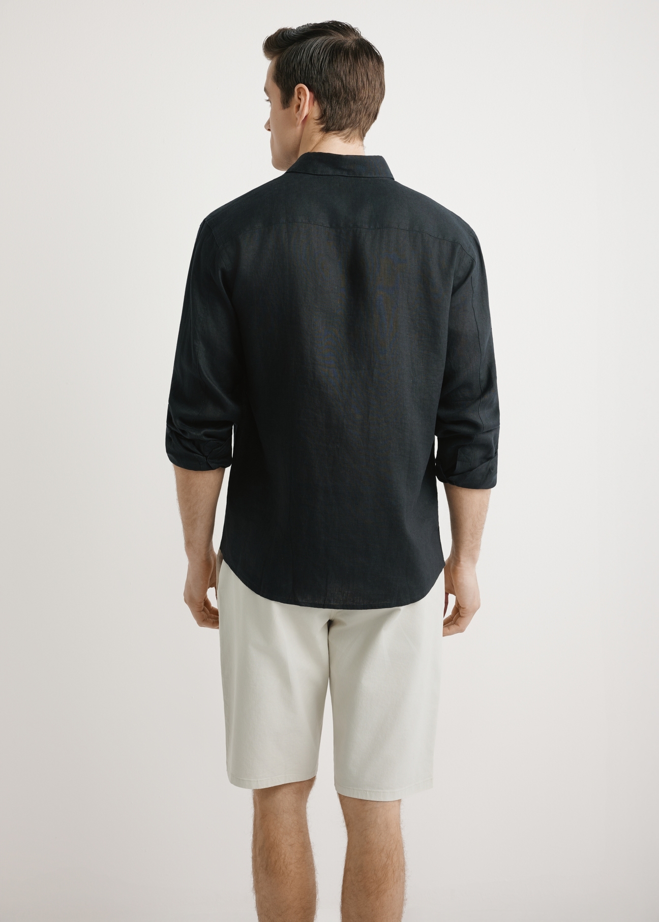 Pánska čierna ľanová košeľa KOSMT-0321A-99(W26) - pohľad na výrobok zozadu, na modelke, na svetlom pozadí. Viditeľná polovica siluety.