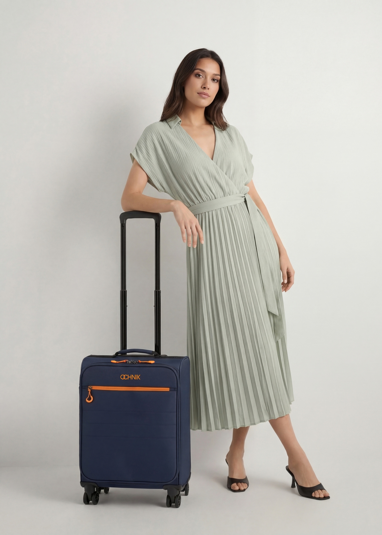 Stredný kufor na kolieskach WALNY-0045-7D-24(W26), pohľad spredu na produkt vedľa siluety modelky.