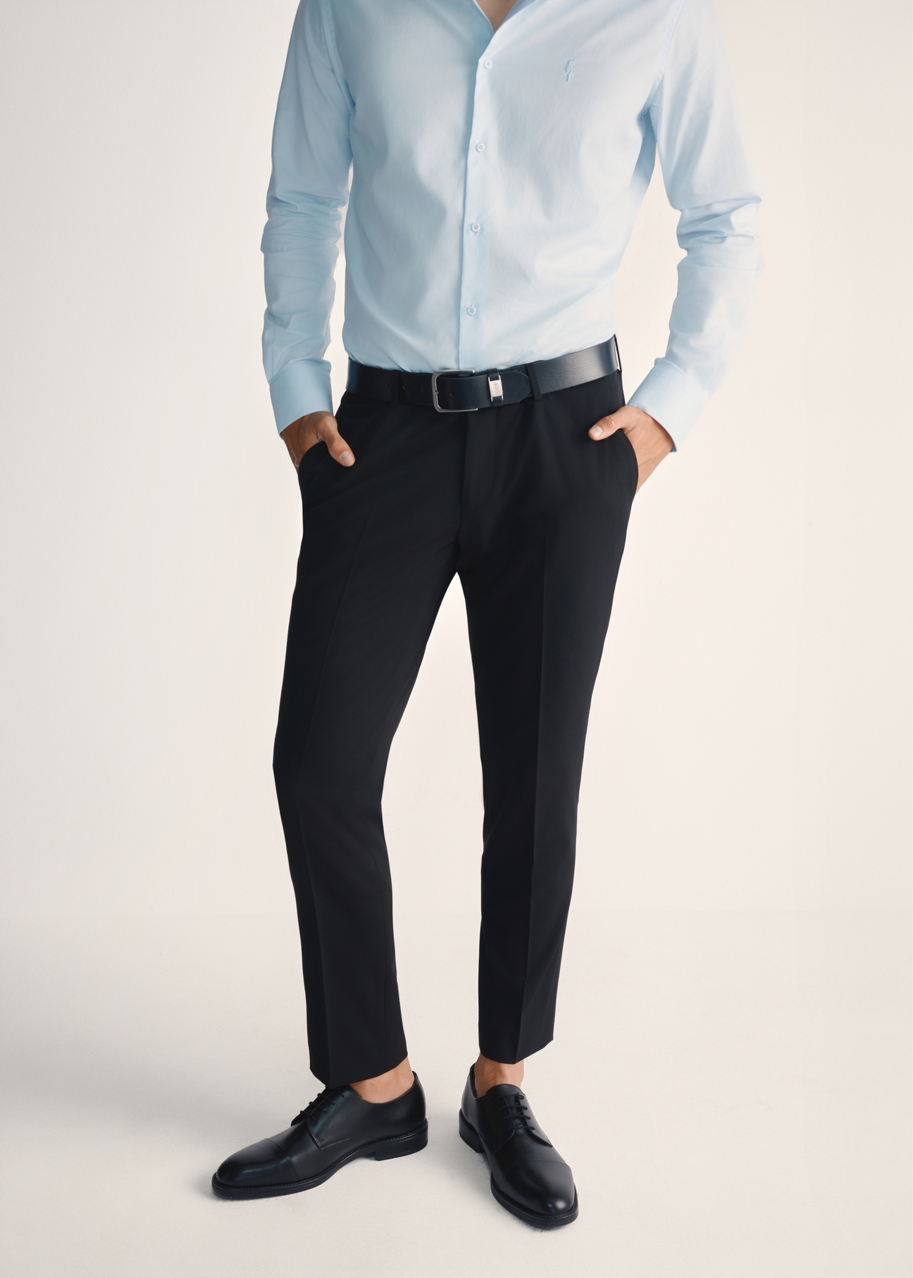 Čierne pánske kožené topánky BUTYM-0512-99(Z25), pohľad spredu na produkt na nohách modelu na svetlom pozadí.