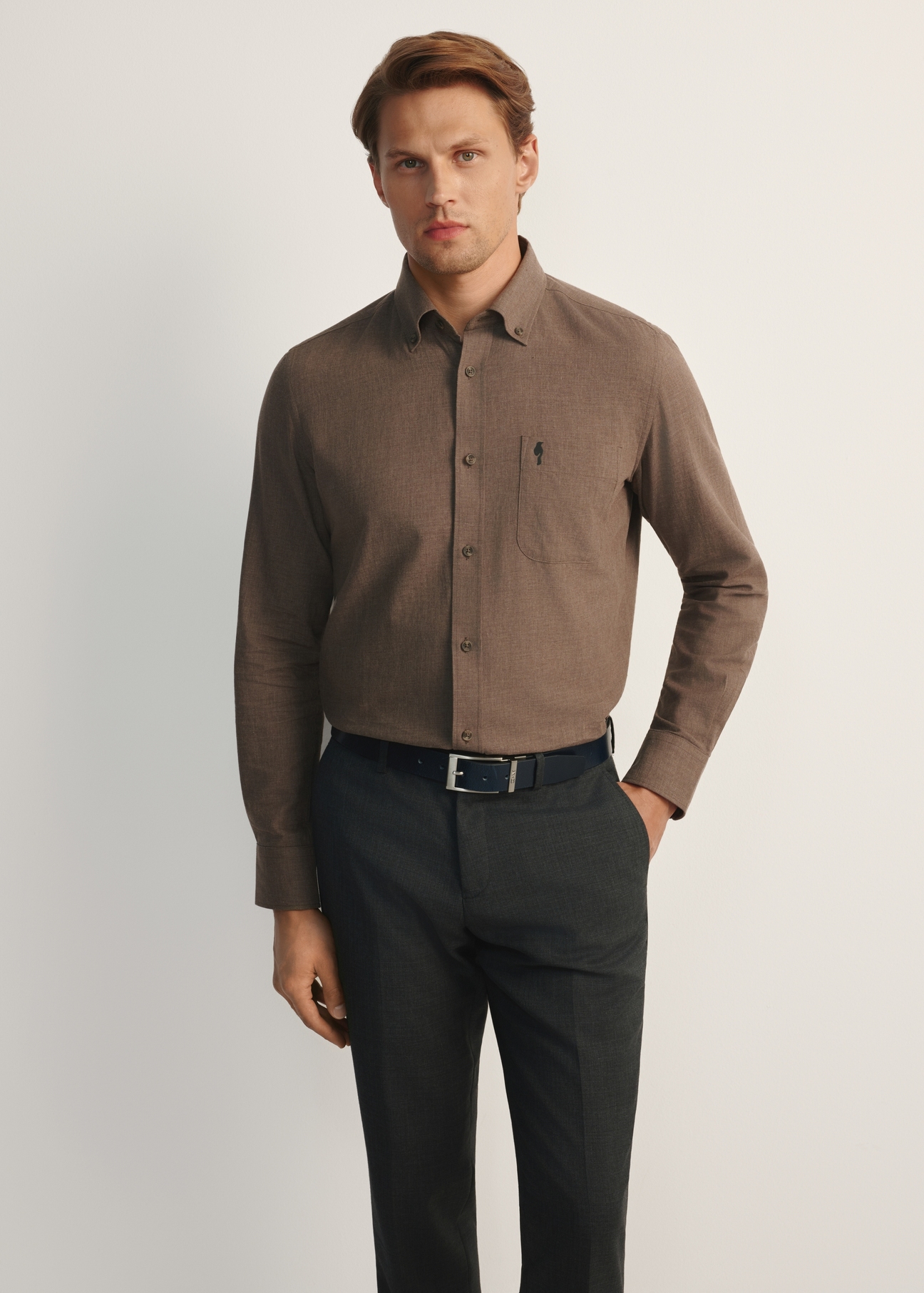 Pánska hnedá košeľa KOSMT-0299A-90(Z25), pohľad spredu na produkt na modelke. Viditeľná polovica siluety.