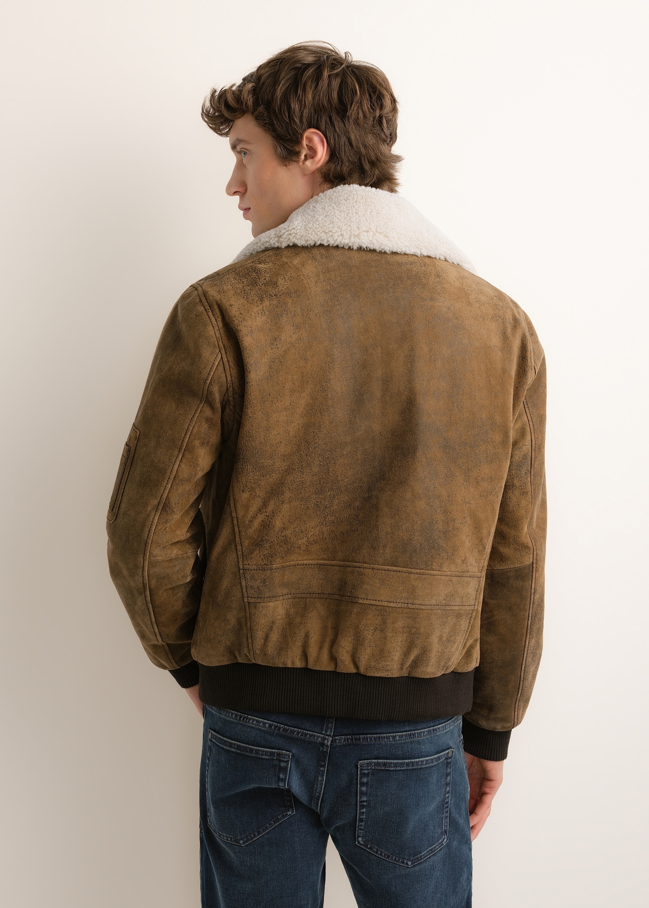 Pánska semišová bomber bunda KURMS-0422-1C(Z26), pohľad na produkt zozadu na modeli. Viditeľná polovica siluety.