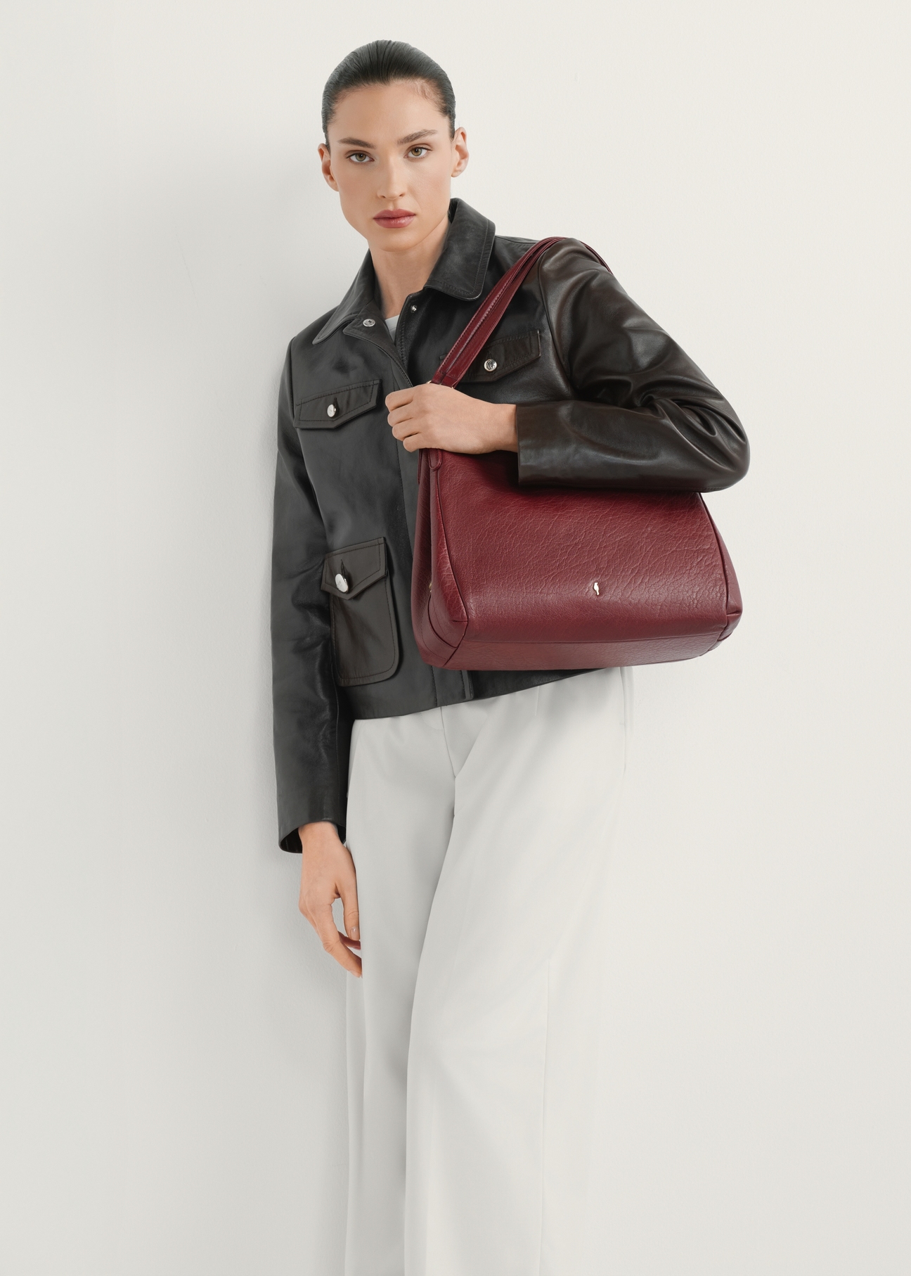 Dámska kožená nákupná taška tmavočervenej farby TORES-0636D-4C(W26) - pohľad na produkt mierne diagonálny, na modelke, na svetlom pozadí. Viditeľná je celá silueta.