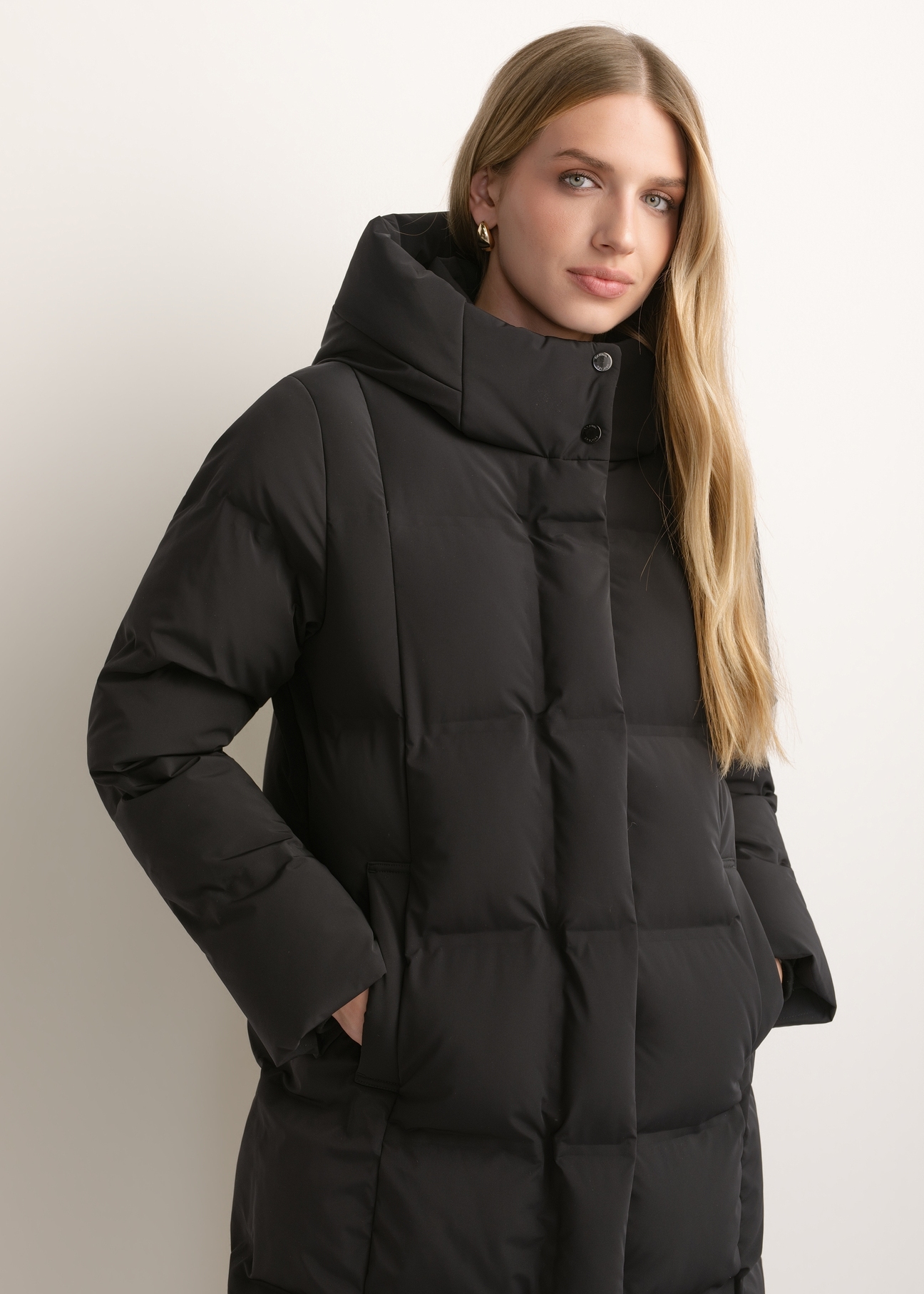 Čierna dámska zimná bunda KURDT-0699-99(Z26), pohľad spredu na produkt na modelke. Viditeľná polovica siluety.