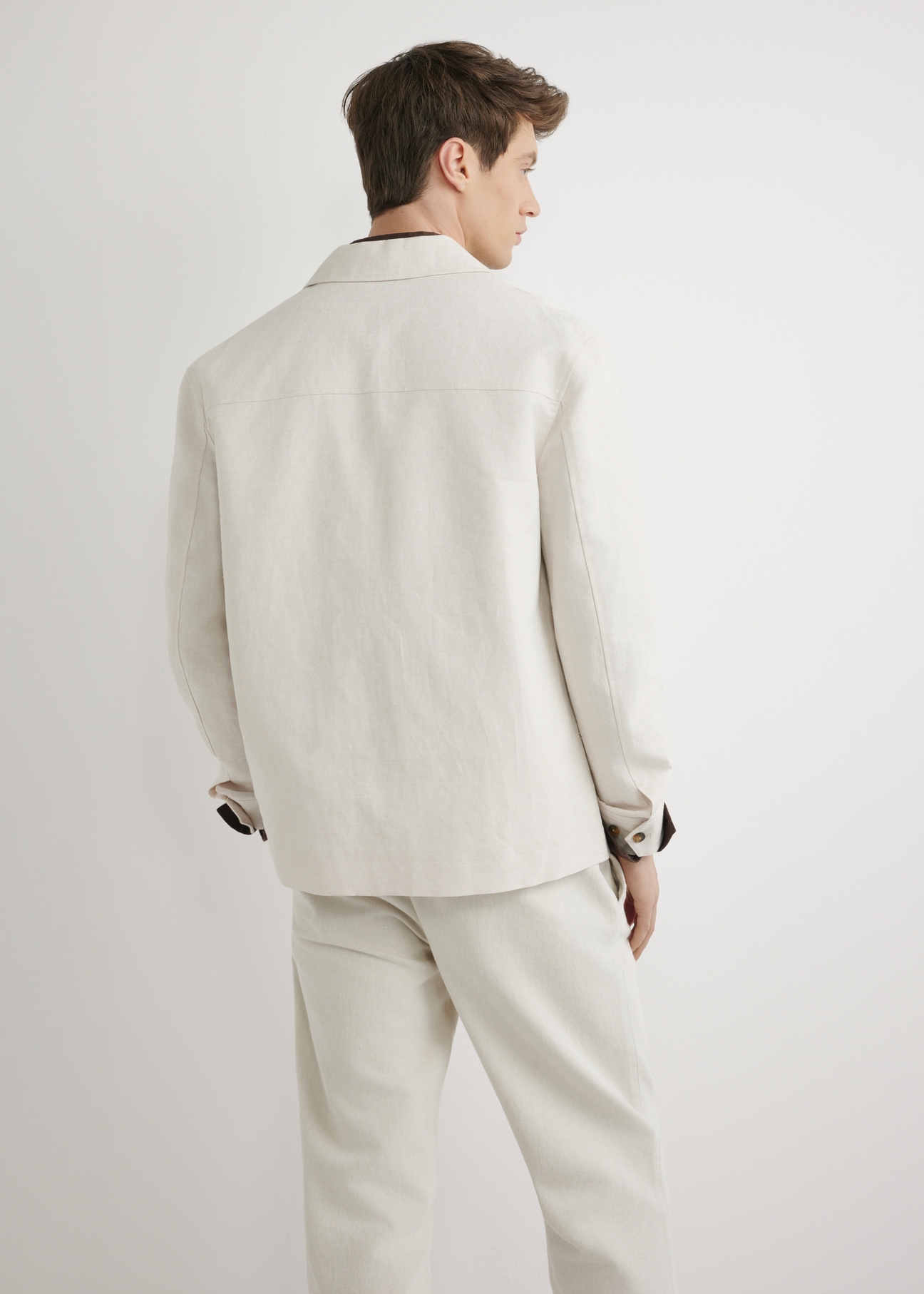 Svetlobéžová pánska ľanová bunda KURMT-0420-1A(W26) - pohľad na výrobok zozadu, na modelke, na svetlom pozadí. Viditeľná polovica siluety.