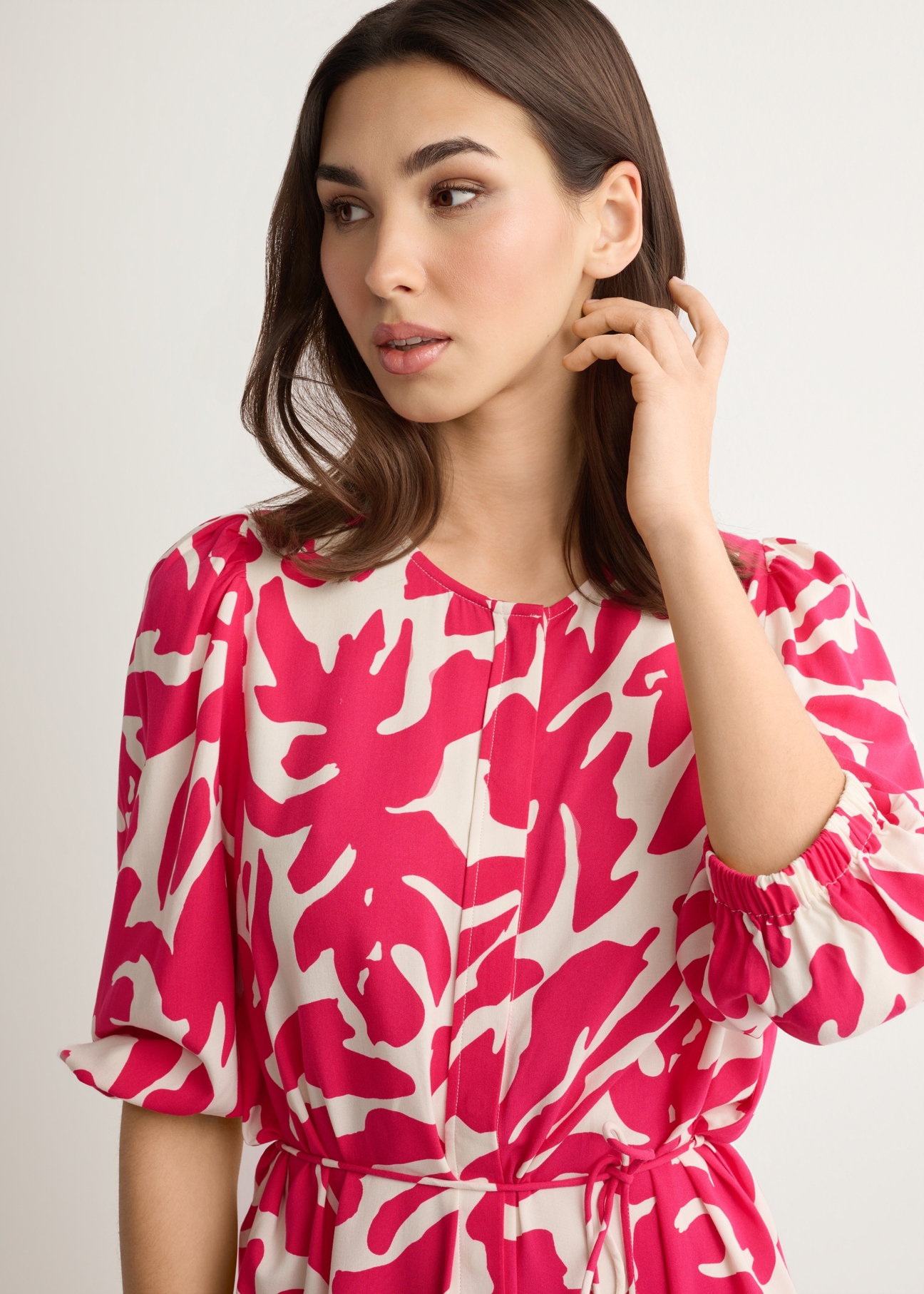 Ružové kvetinové viskózové šaty SUKDT-0271-5P(W26), pohľad spredu na výrobok na modelke. Viditeľná polovica siluety.